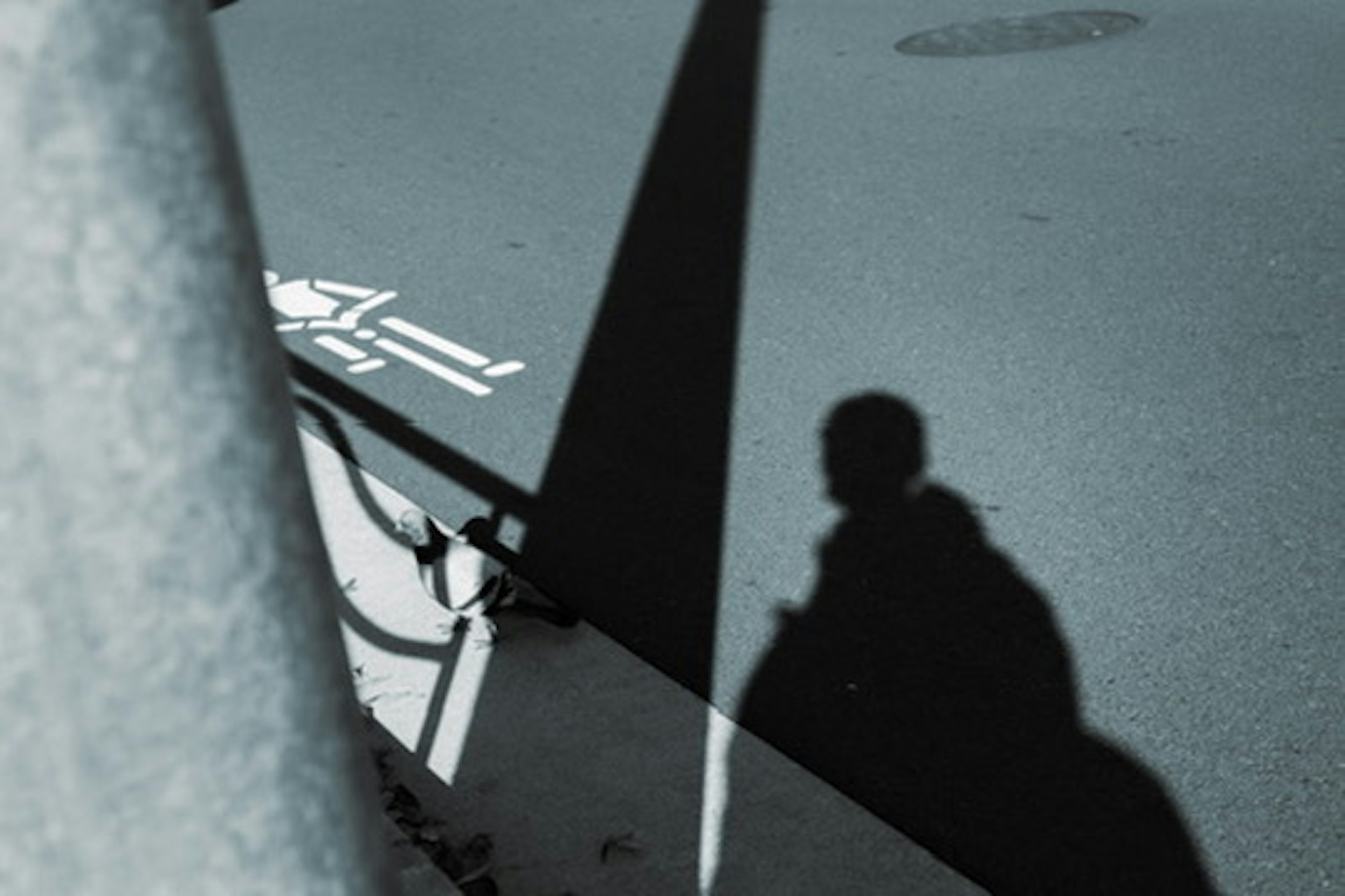 Scène urbaine avec une ombre et un symbole de handicap blanc au sol