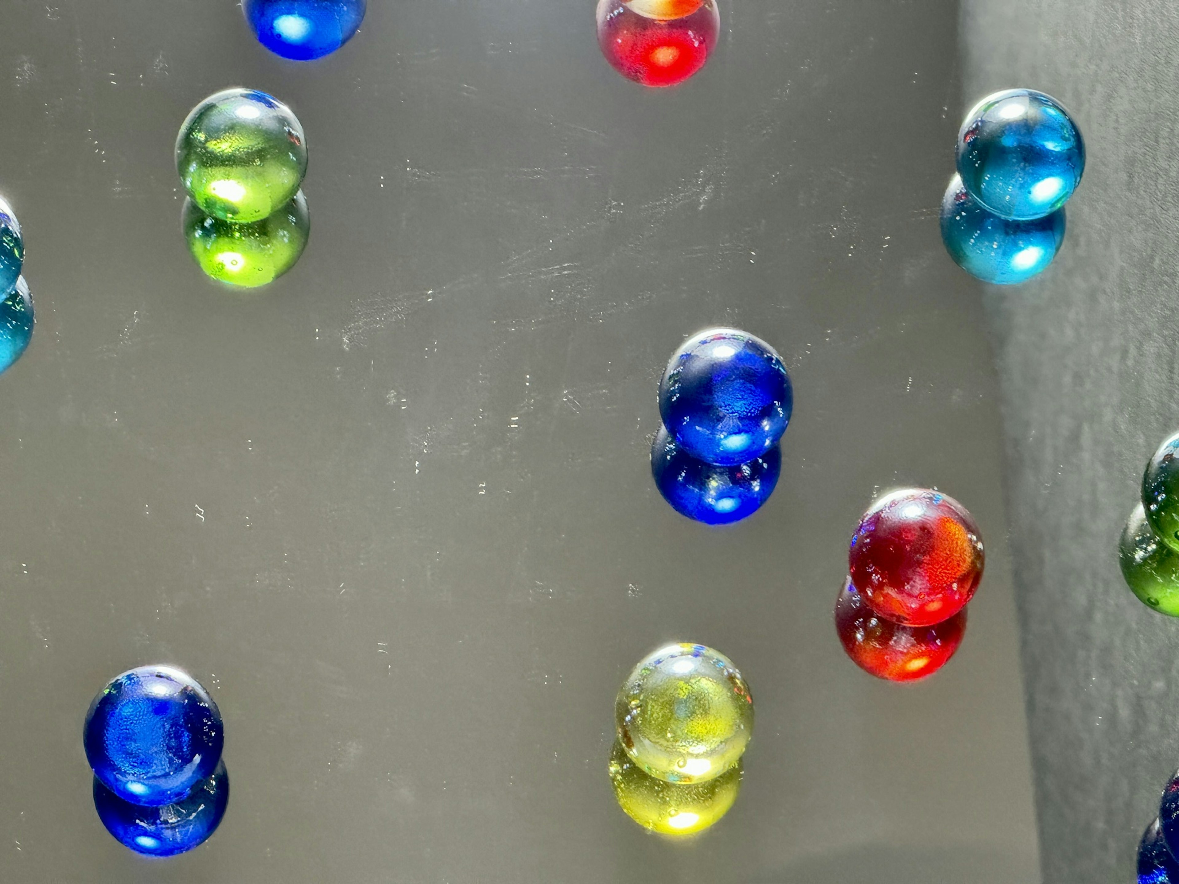 Colorful marbles floating on a glossy surface