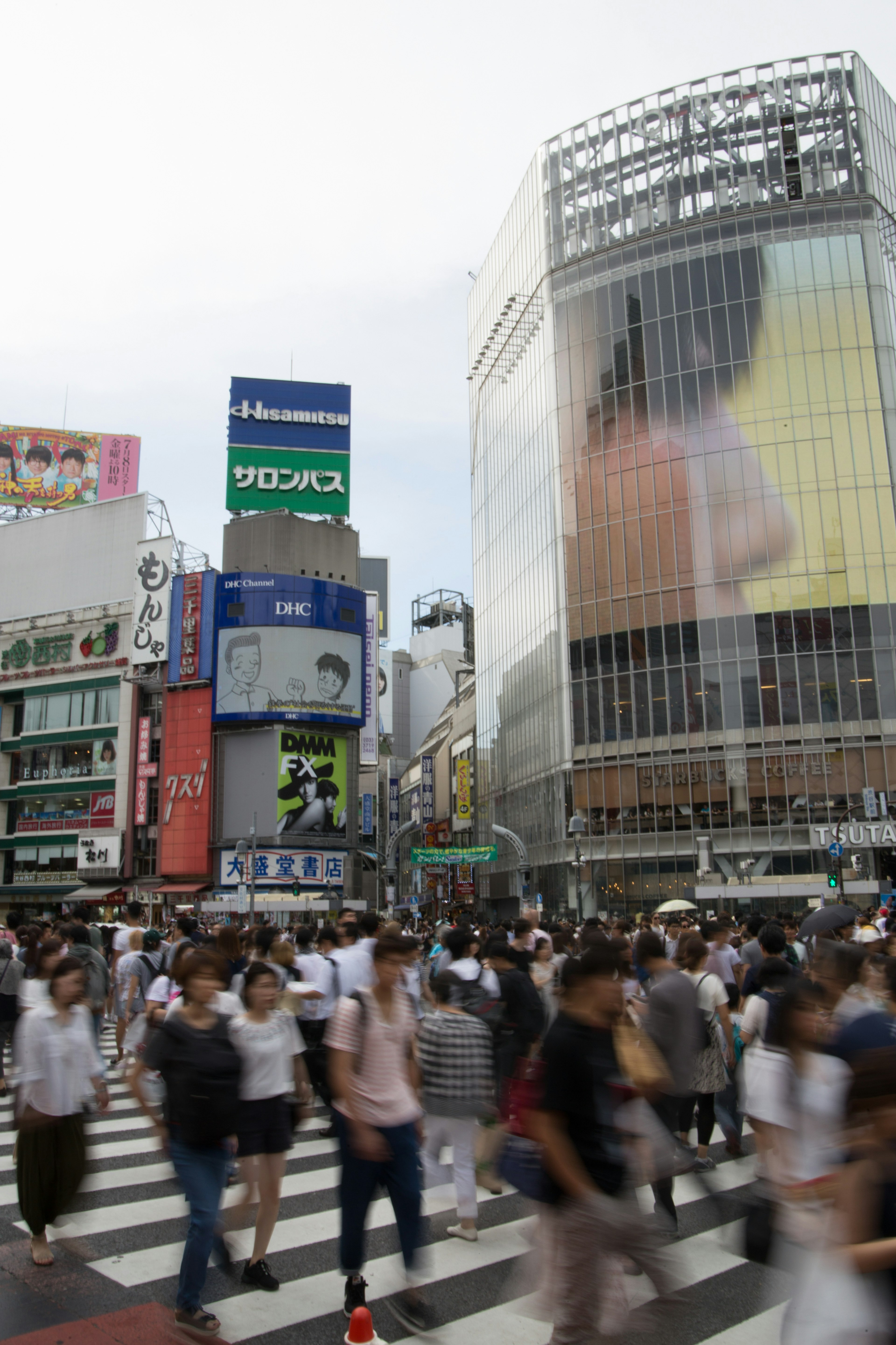 Cảnh đông đúc tại ngã tư Shibuya với đám đông người đi bộ và quảng cáo lớn