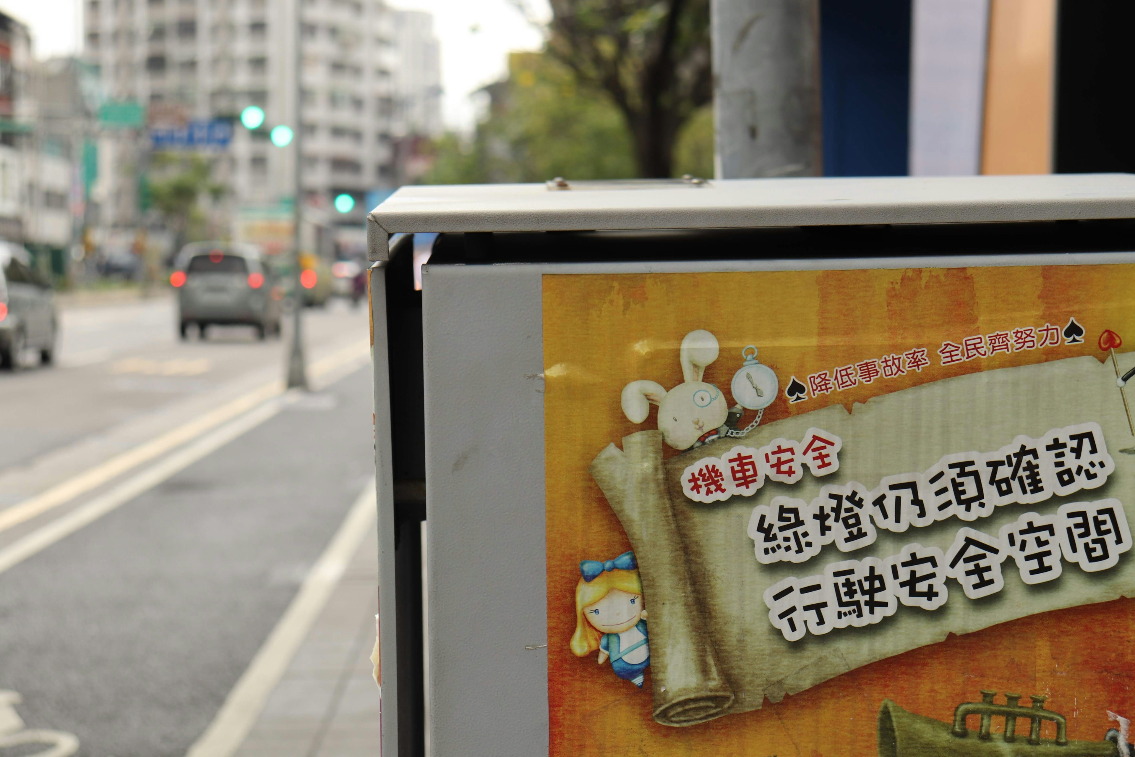 A street corner sign featuring cute characters and a message about traffic safety