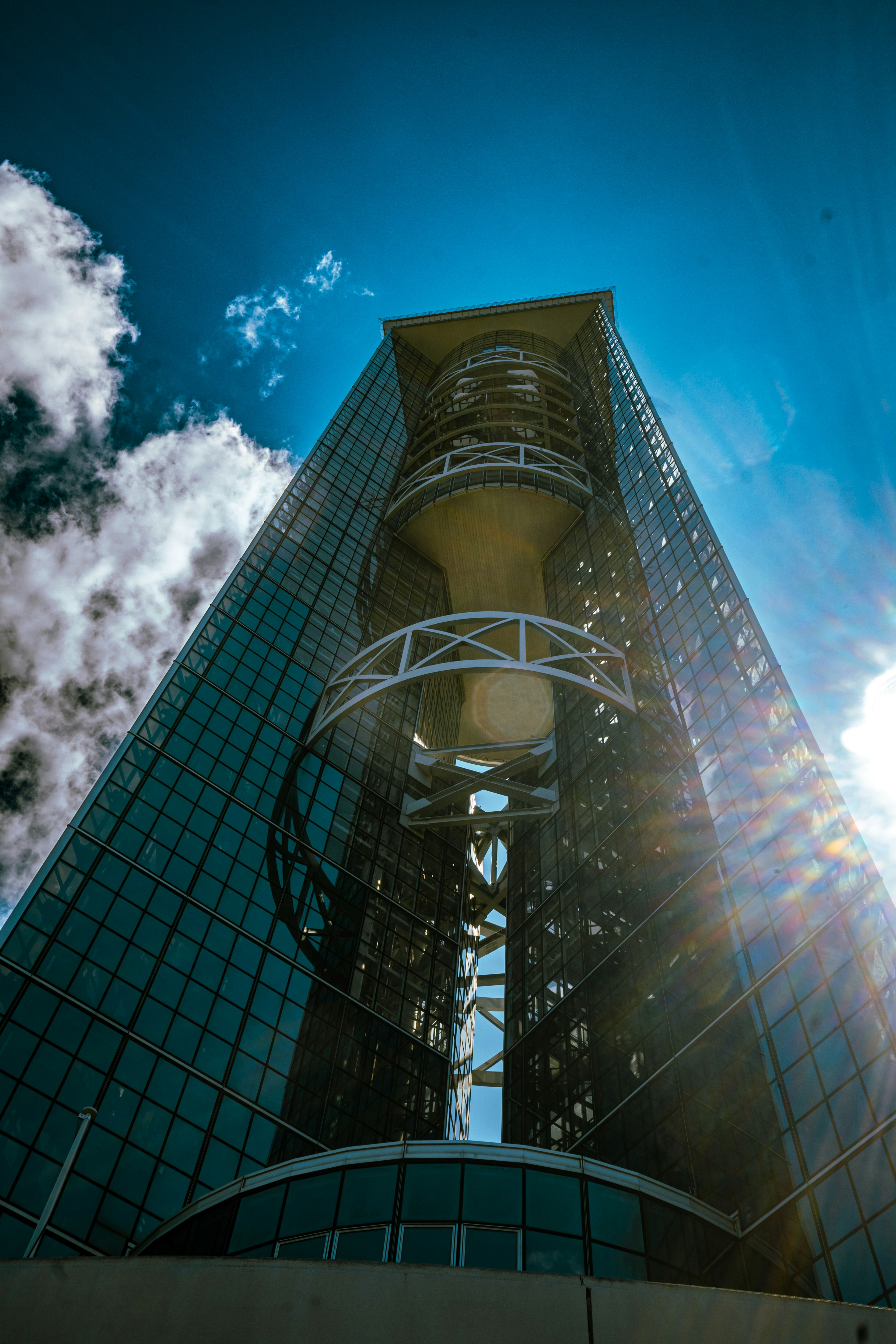 Blick von unten auf einen Wolkenkratzer mit blauem Himmel und Wolken