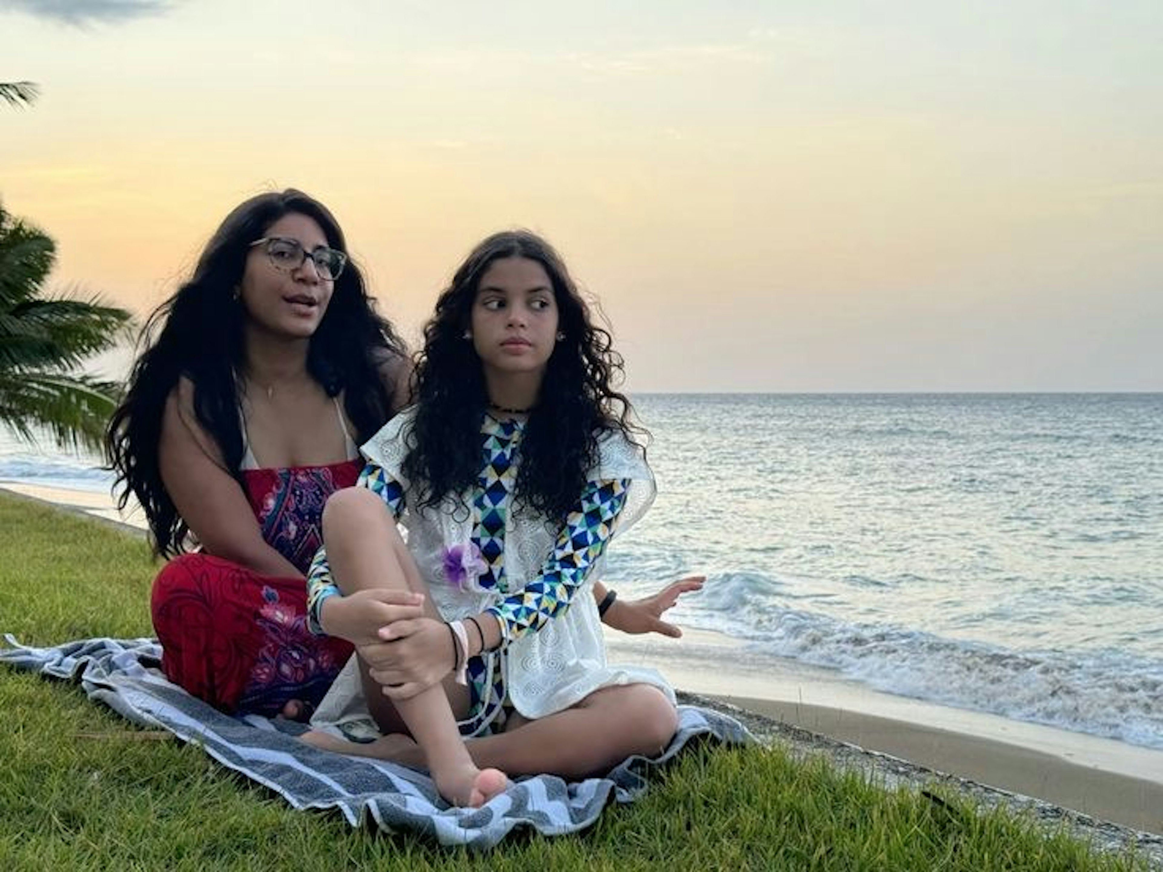 Two girls relaxing on the beach at sunset surrounded by nature