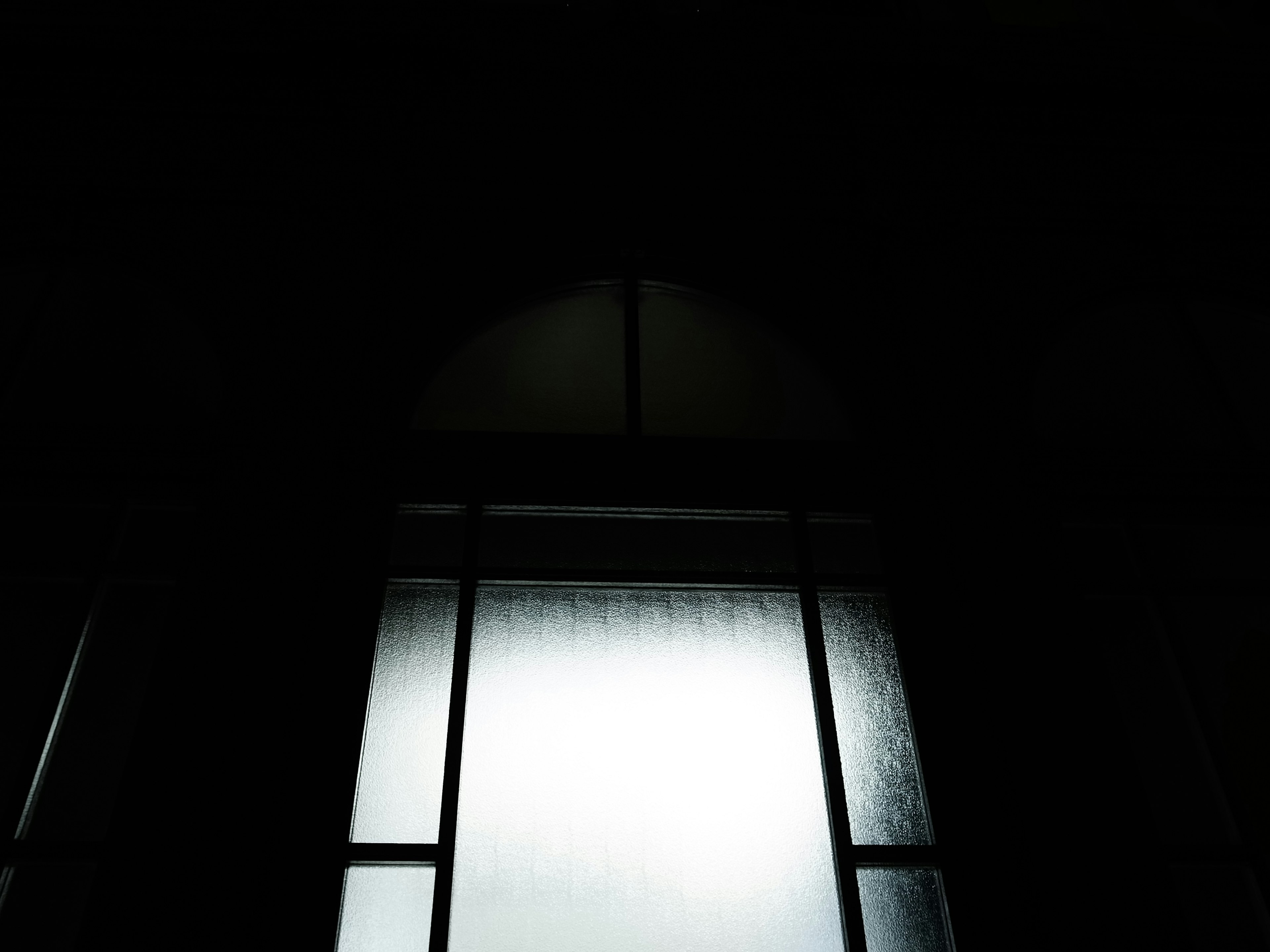 Silhouette of a window in a dim room light streaming through