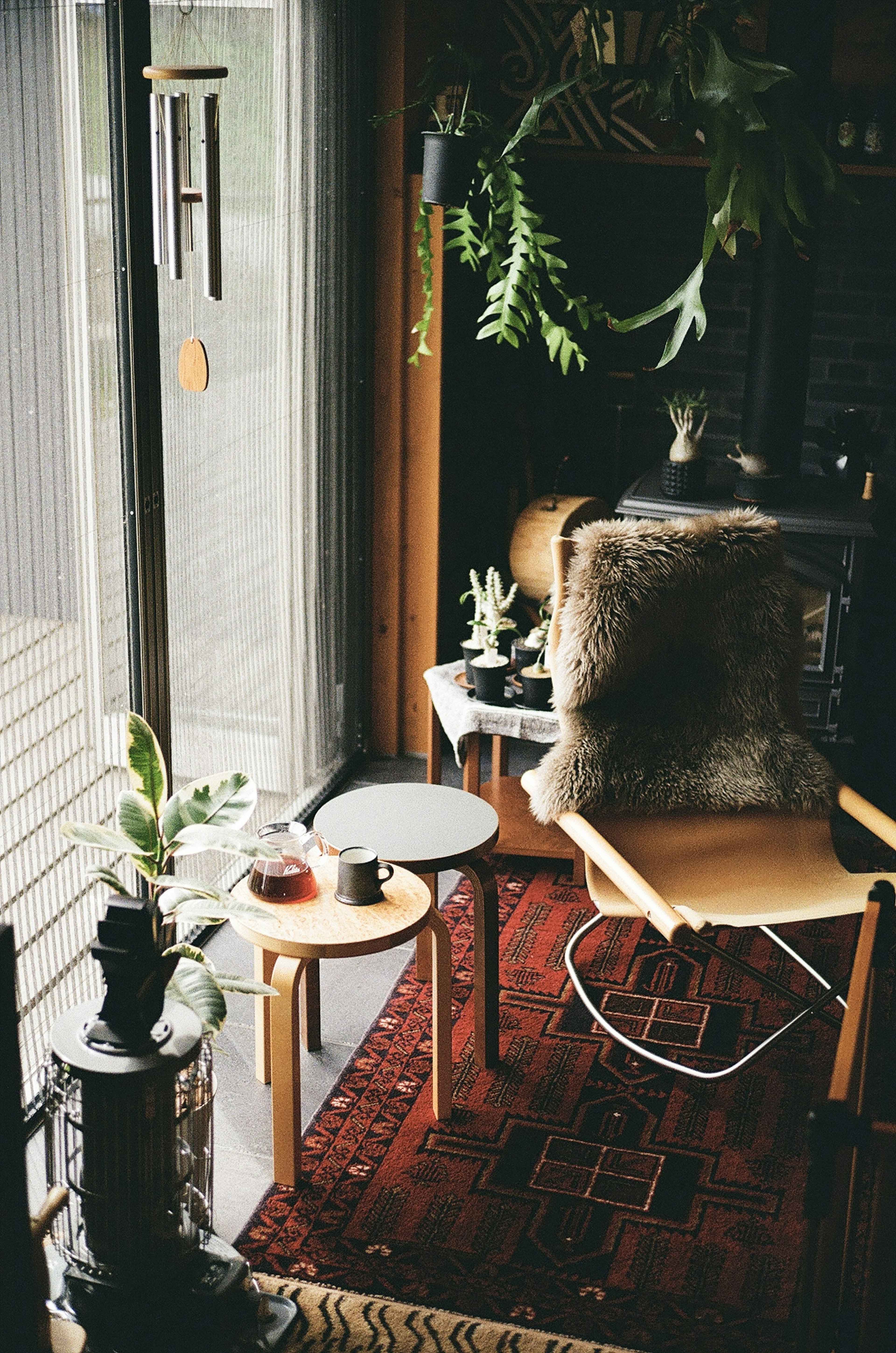 Cozy corner of an indoor space featuring a chair and table with plants and a fur cushion