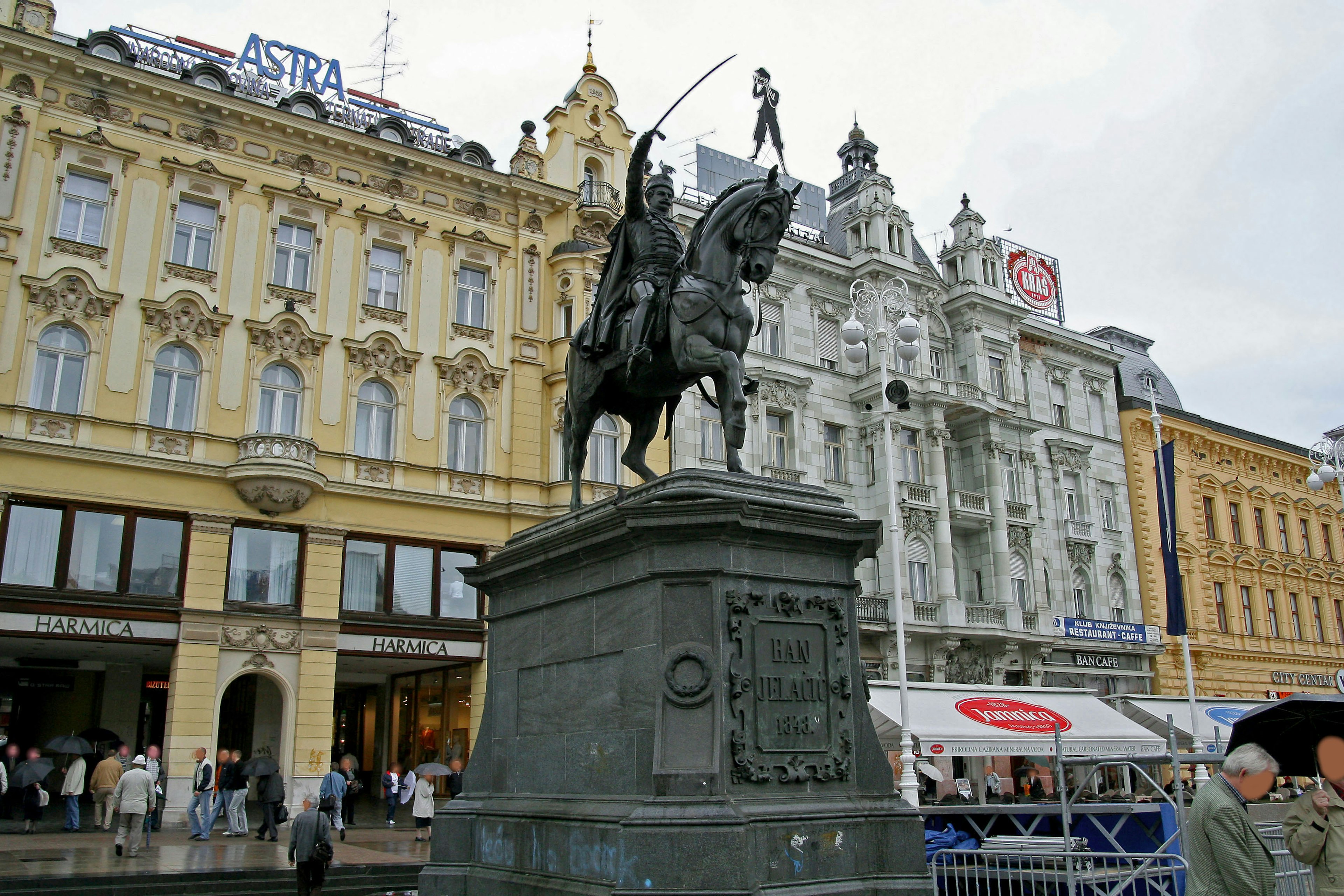 Statue of a knight on horseback with historic buildings in the background