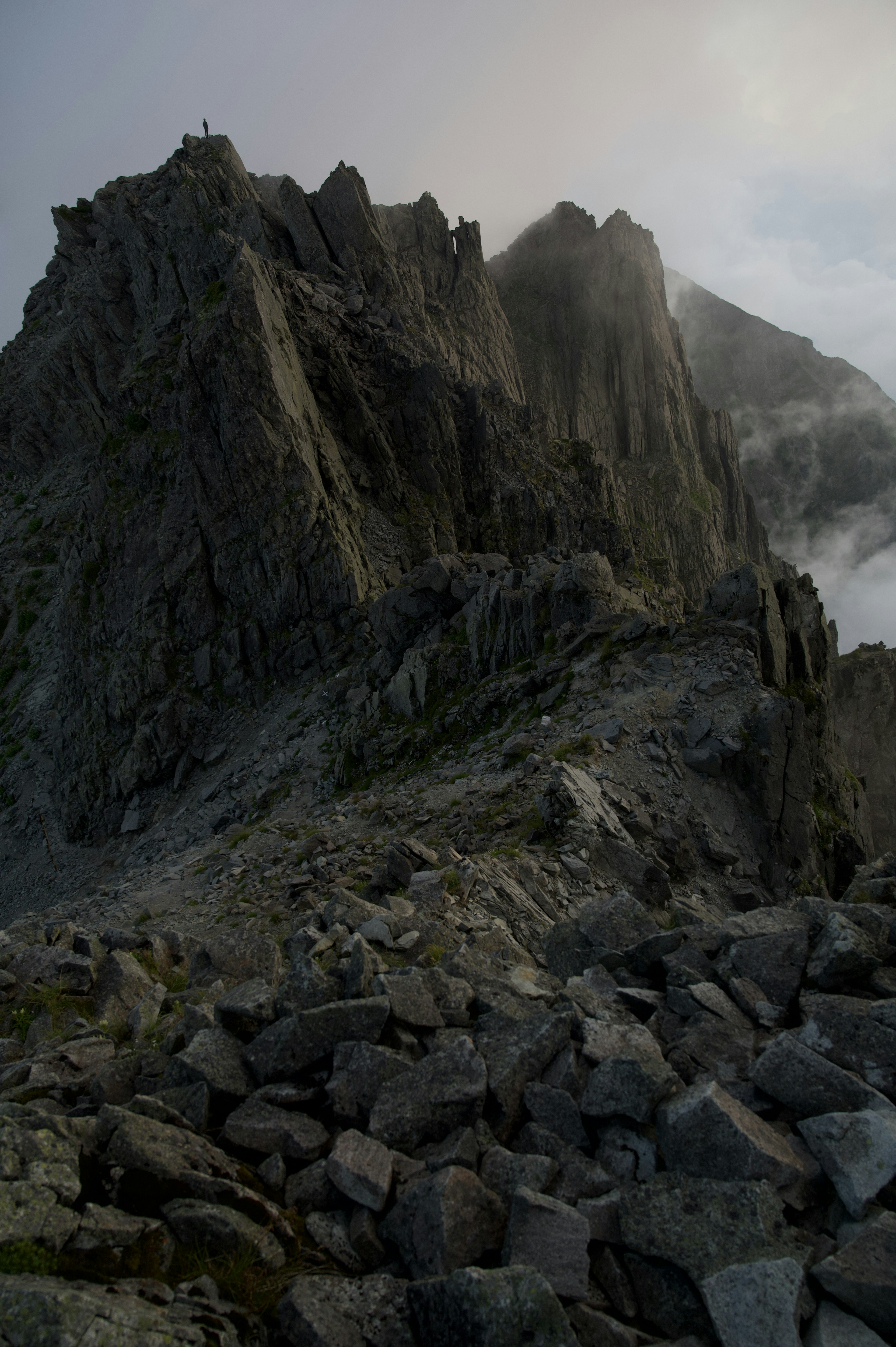 Rugged mountain ridge with rocky terrain and mist