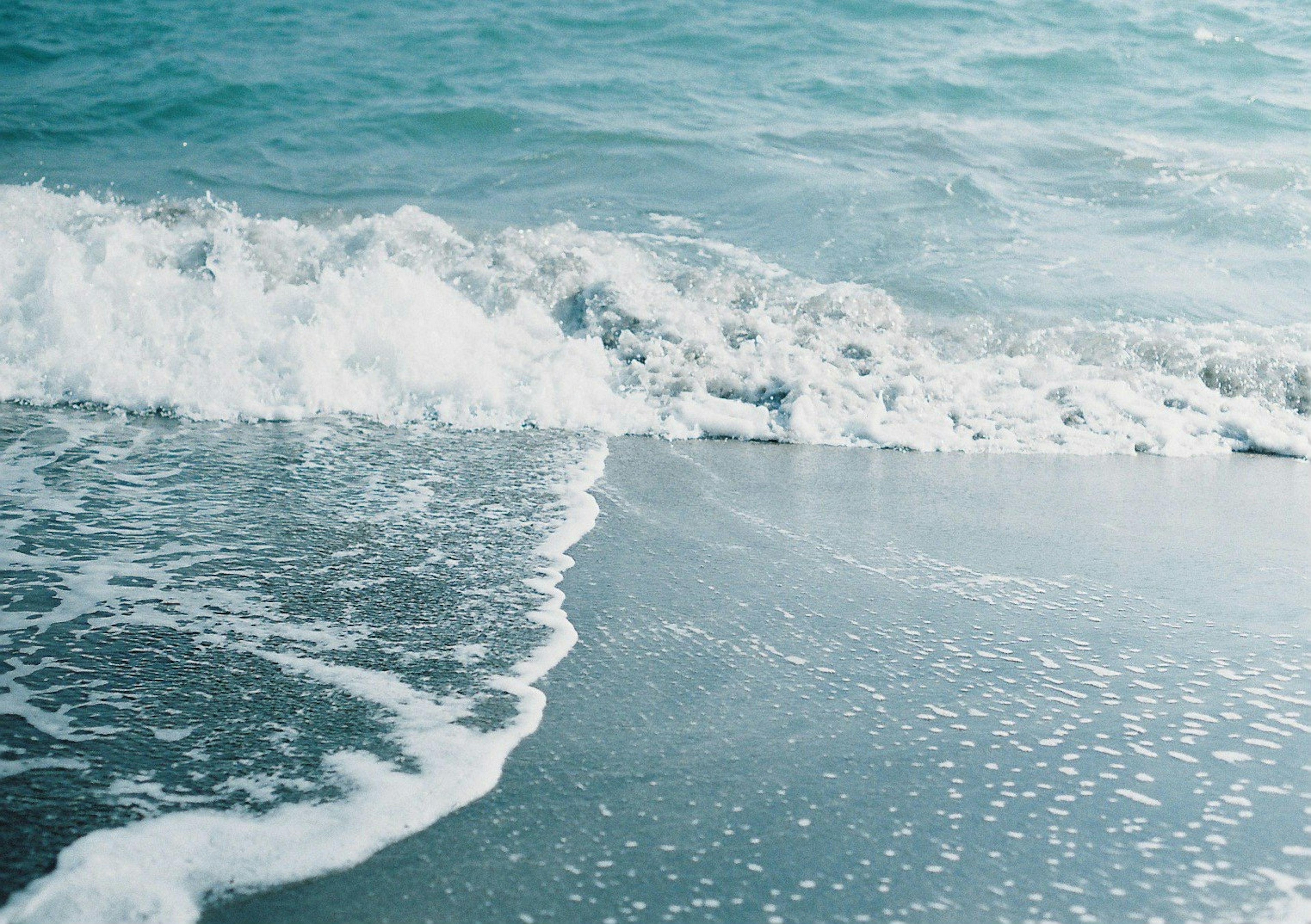 Onde dolci dell'oceano che si infrangono su una spiaggia sabbiosa