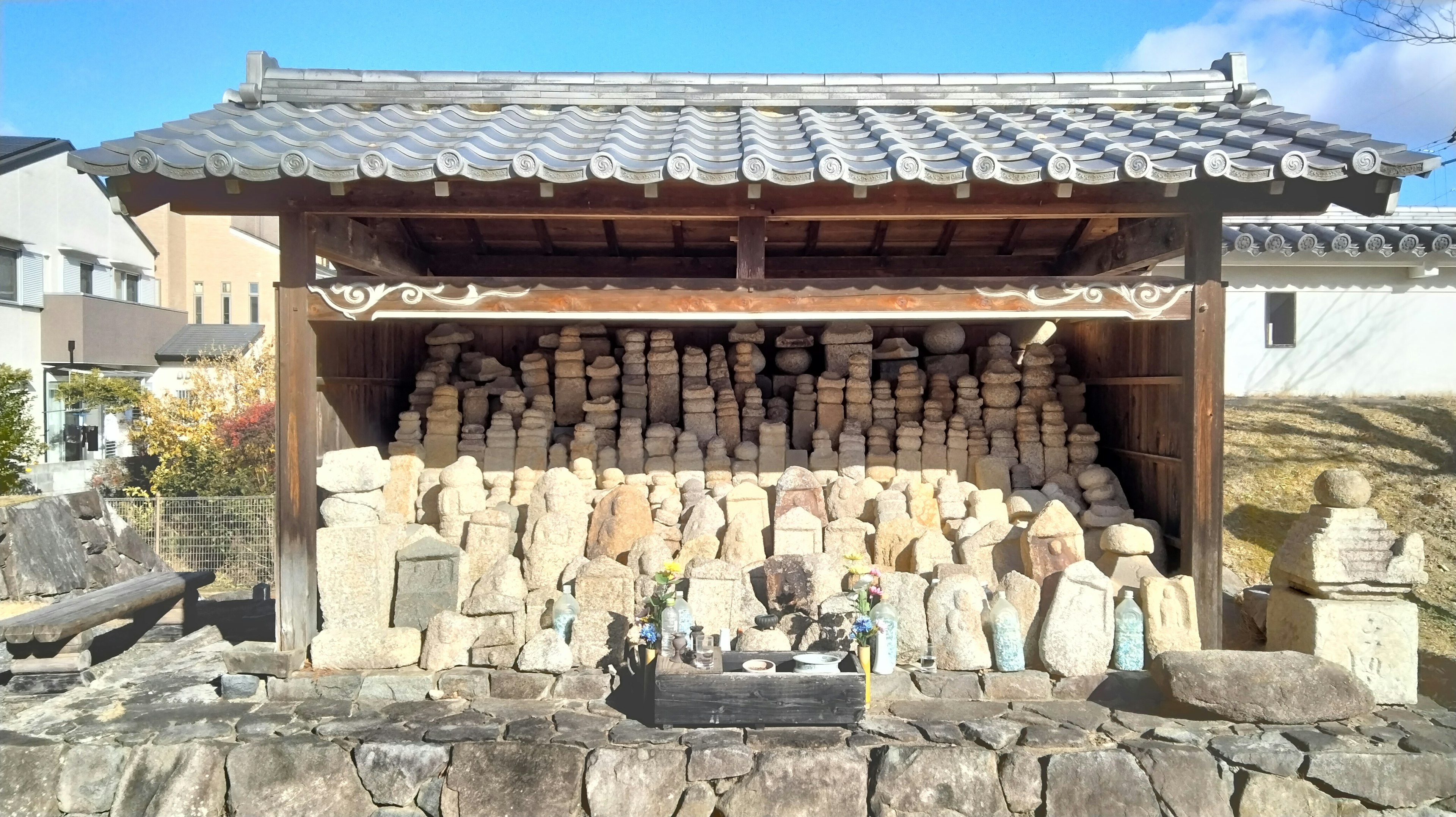 Una estructura con techo que exhibe numerosas estatuas de piedra apiladas de diversas formas