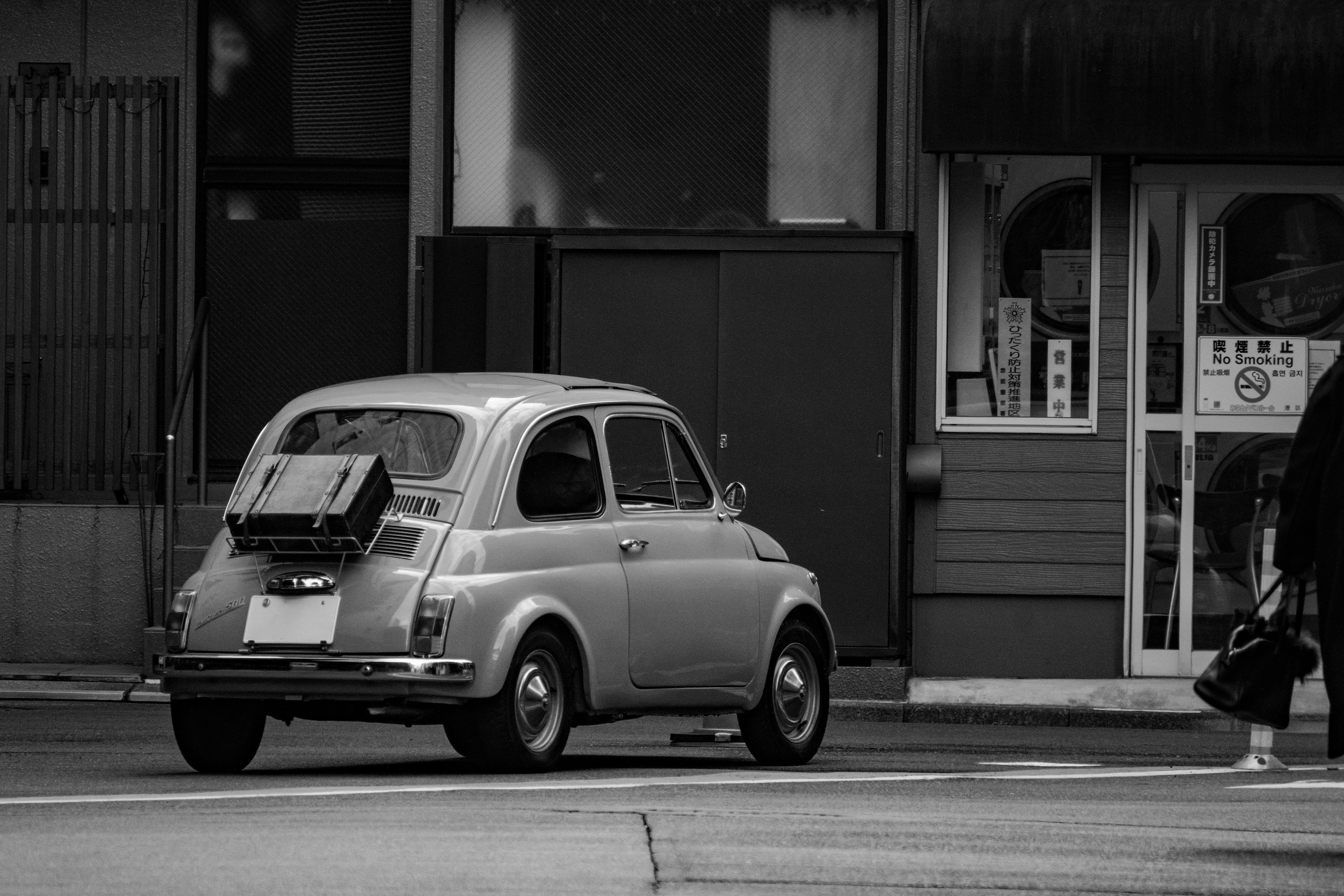 Vintage Fiat-Auto an einer Straßenecke in Schwarzweiß geparkt