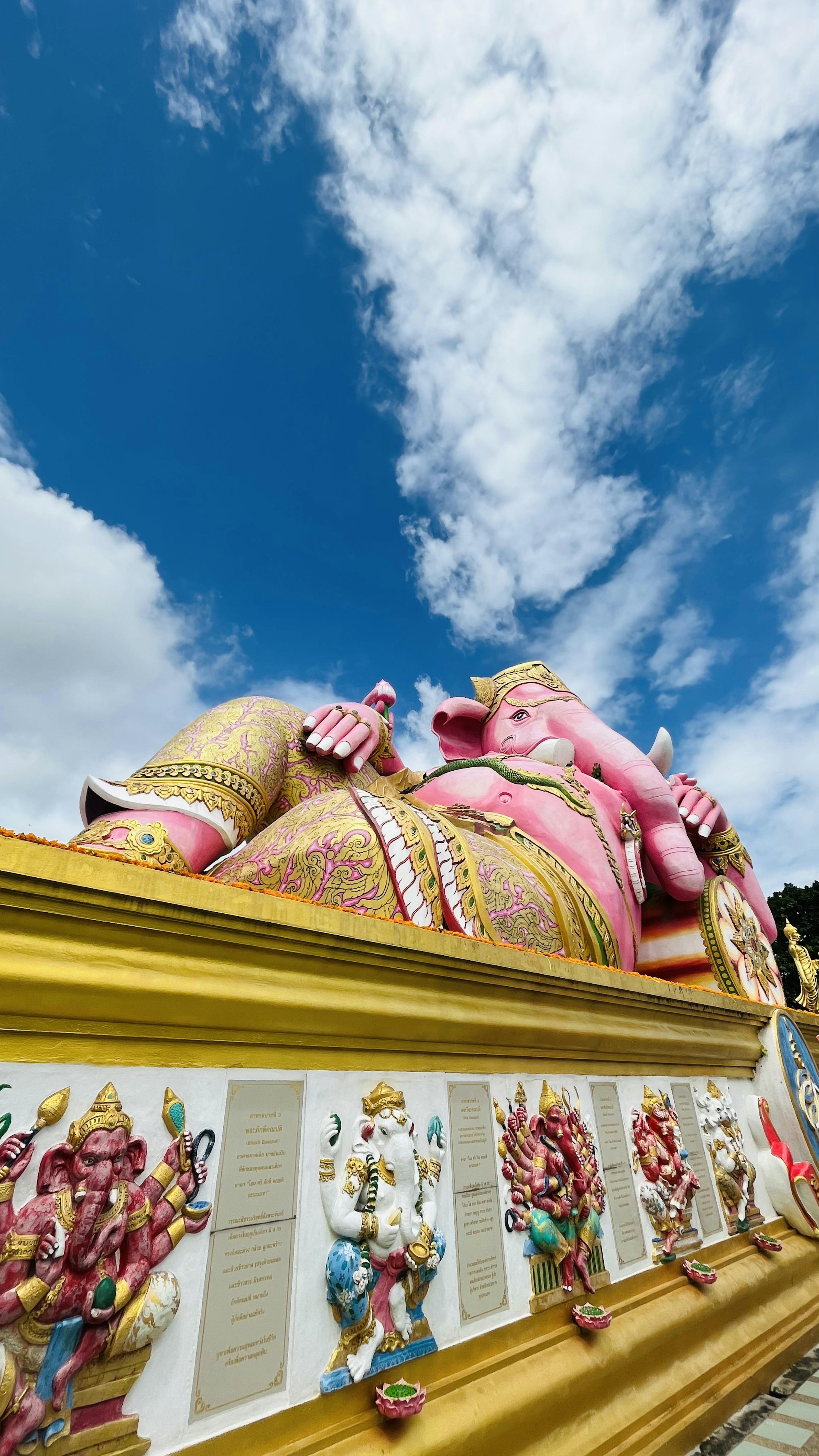 Patung Ganesha besar berwarna pink dengan latar belakang langit biru