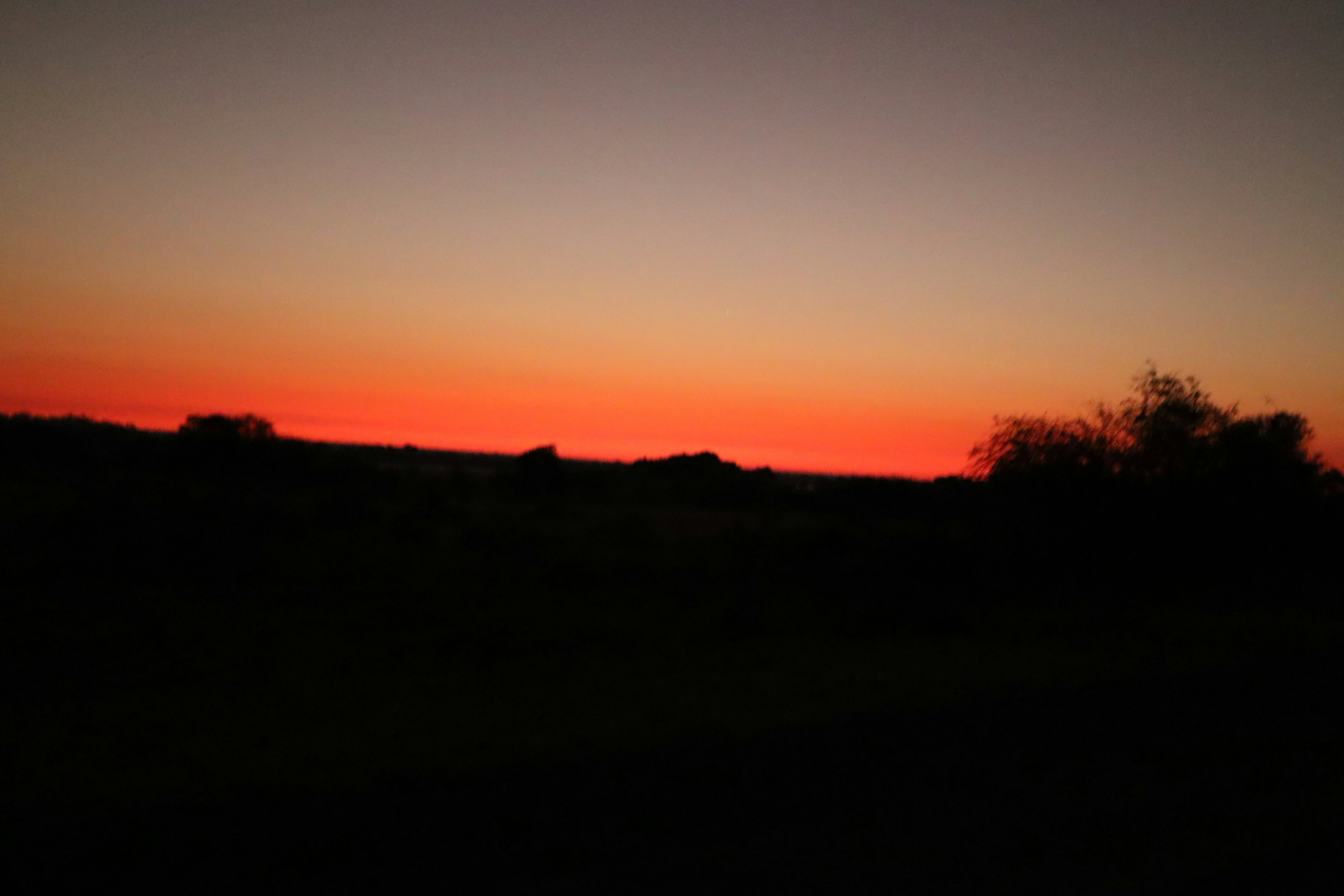 Paisaje con un atardecer de degradado naranja y púrpura