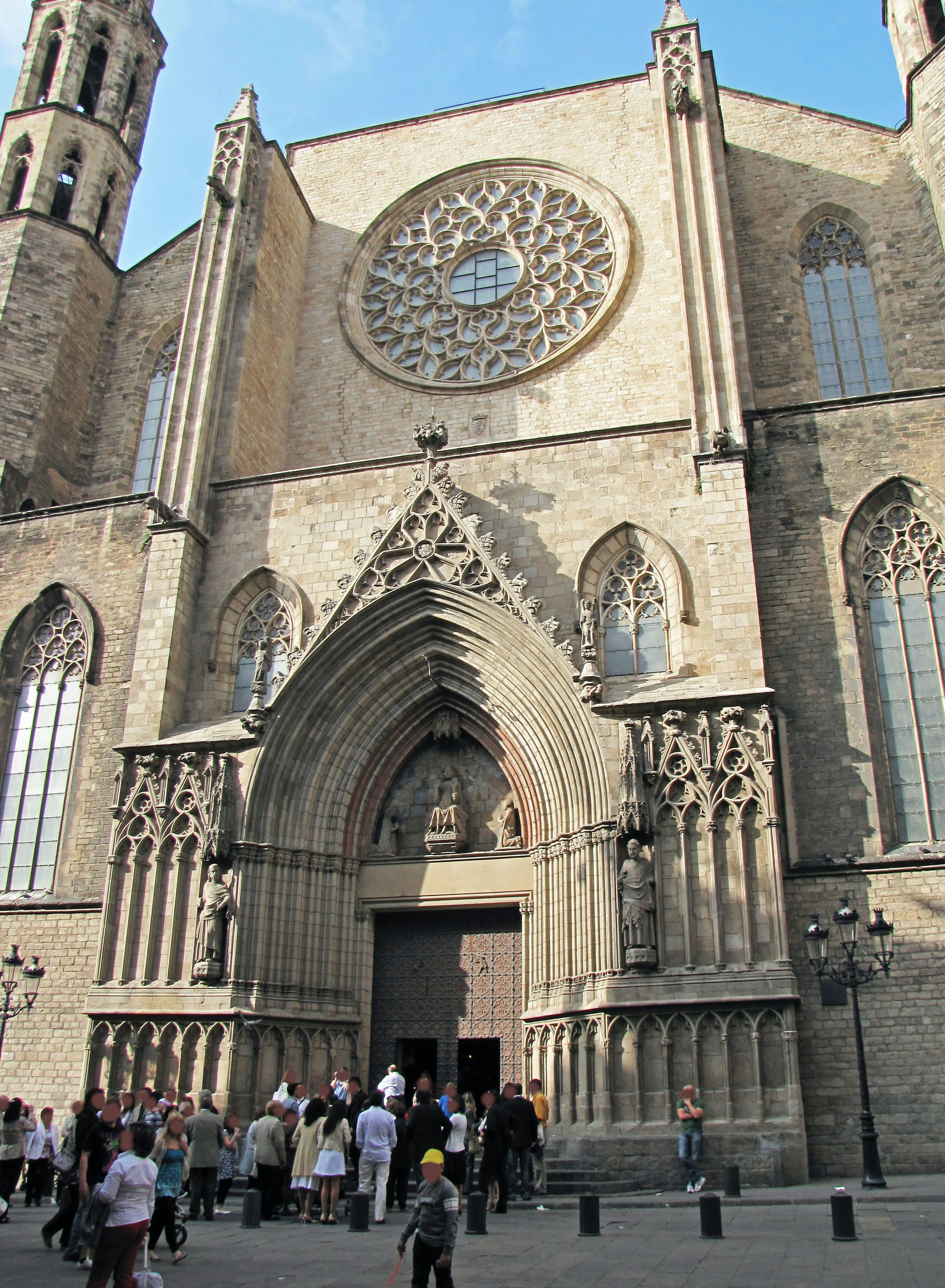 Fasad gereja Gothic di Barcelona dengan jendela mawar besar dan patung rumit