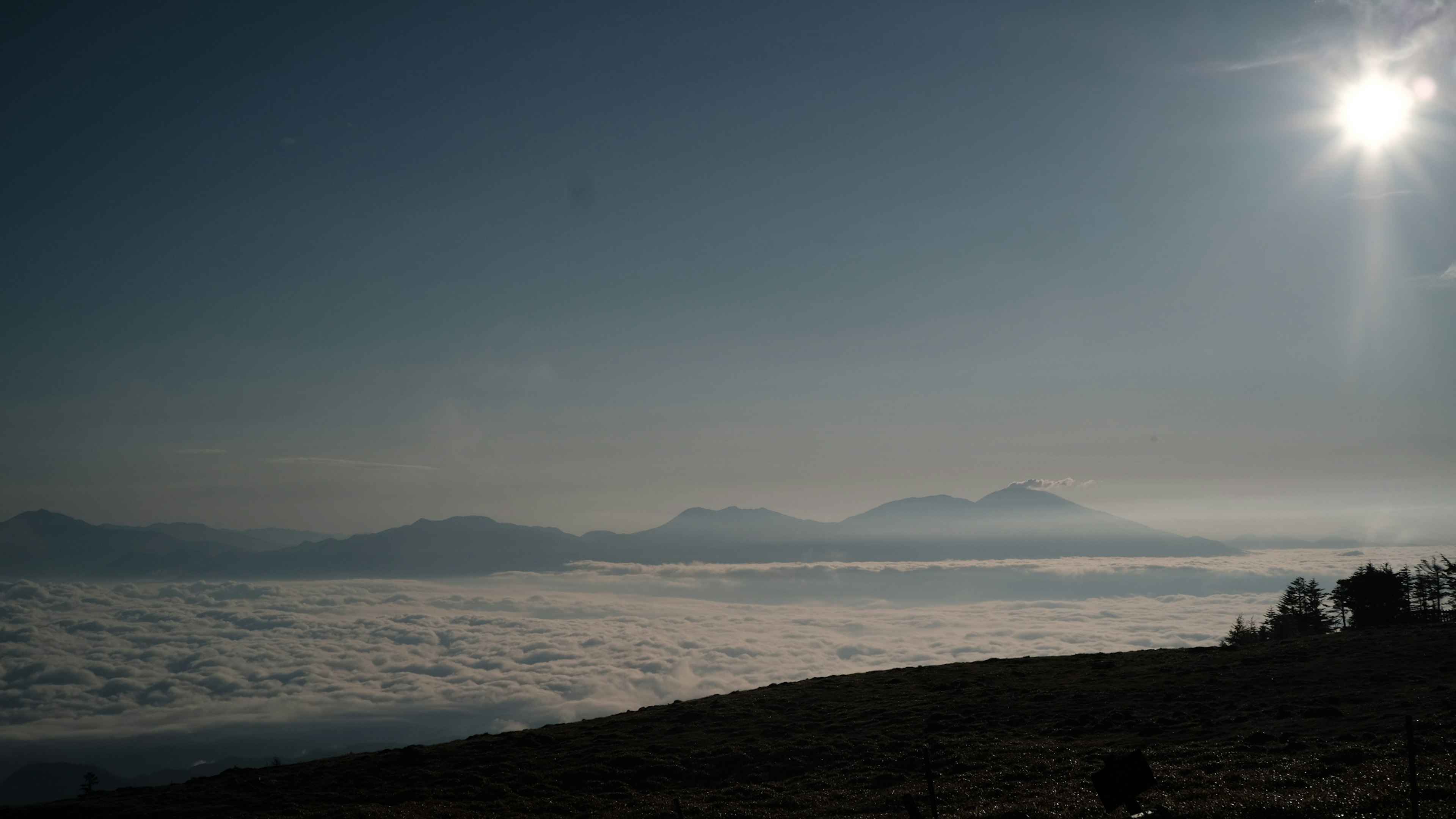 青空と雲海の風景 太陽が輝く山々のシルエット