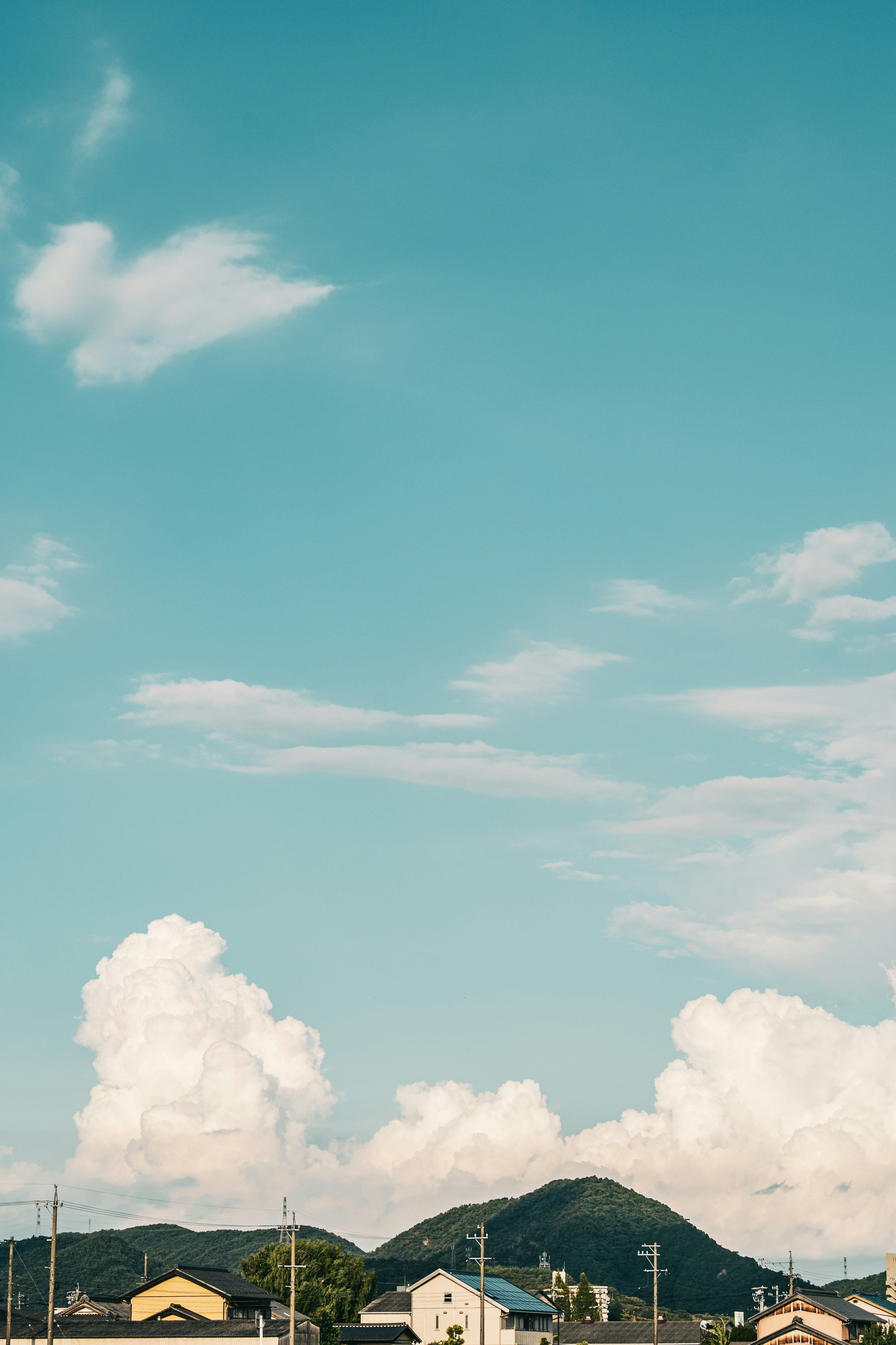 青空と白い雲が広がる風景 山が背景に見える