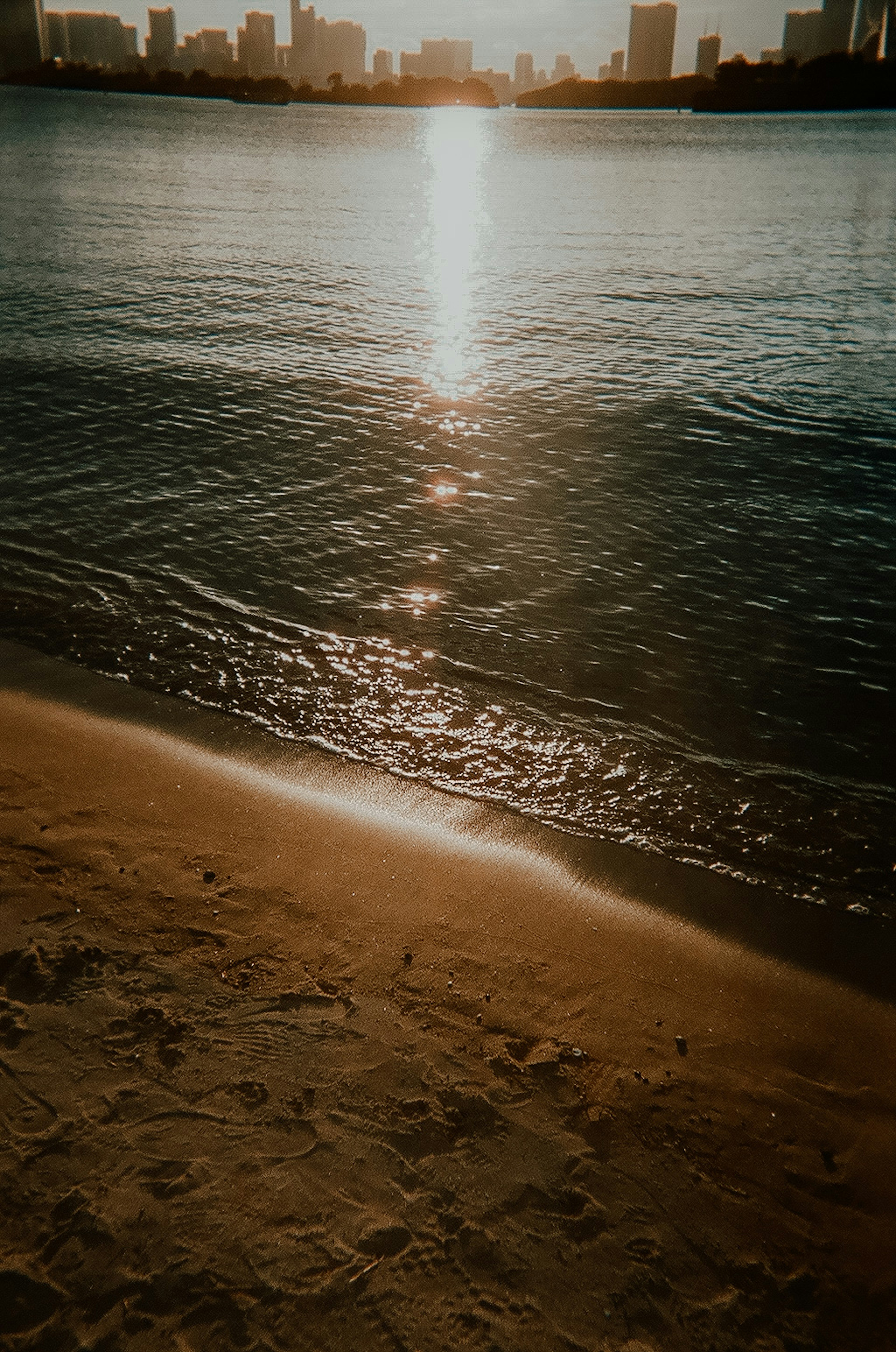 夕日が水面に反射するビーチの風景