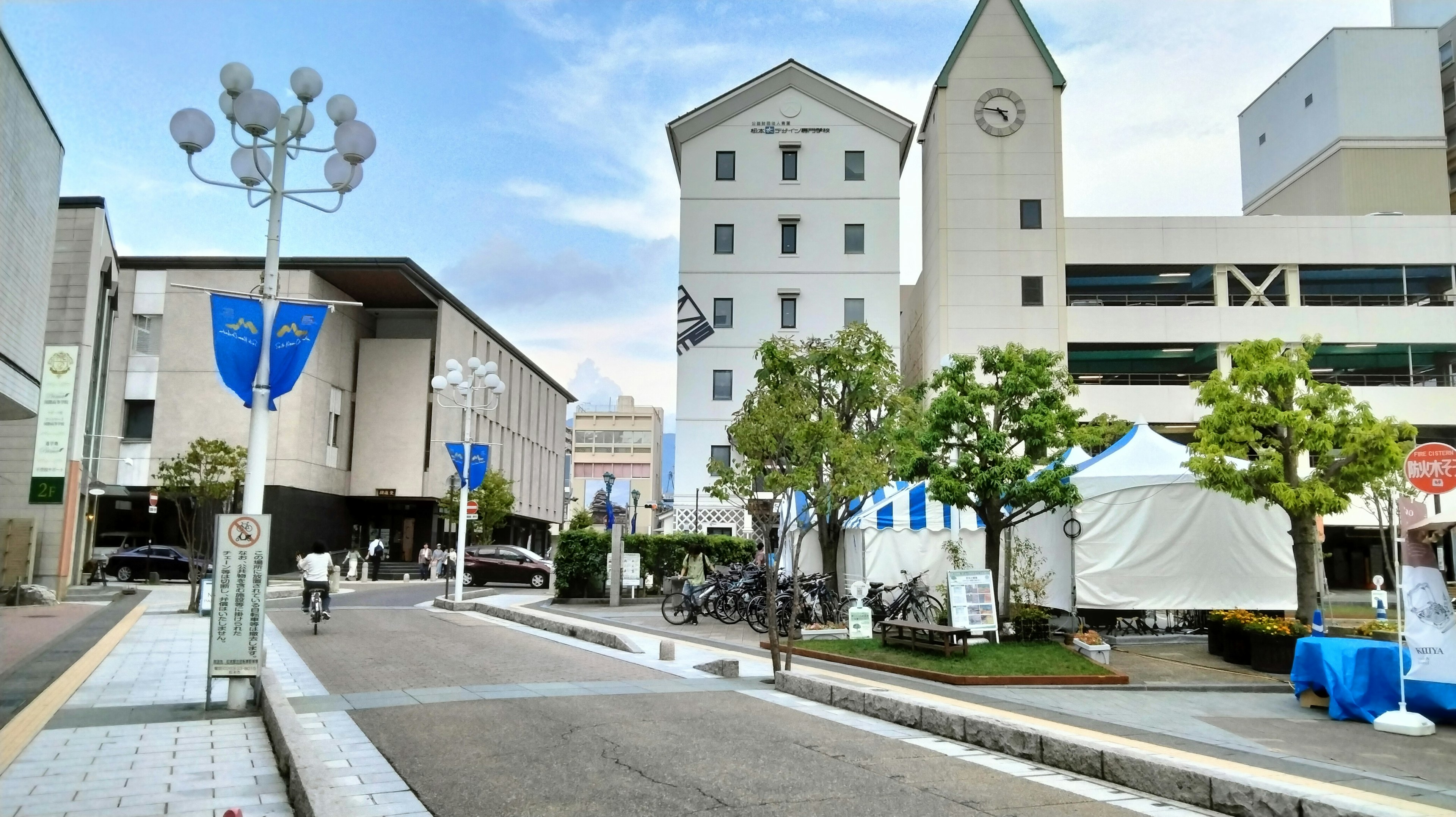 Quiet street scene with buildings and trees under blue sky