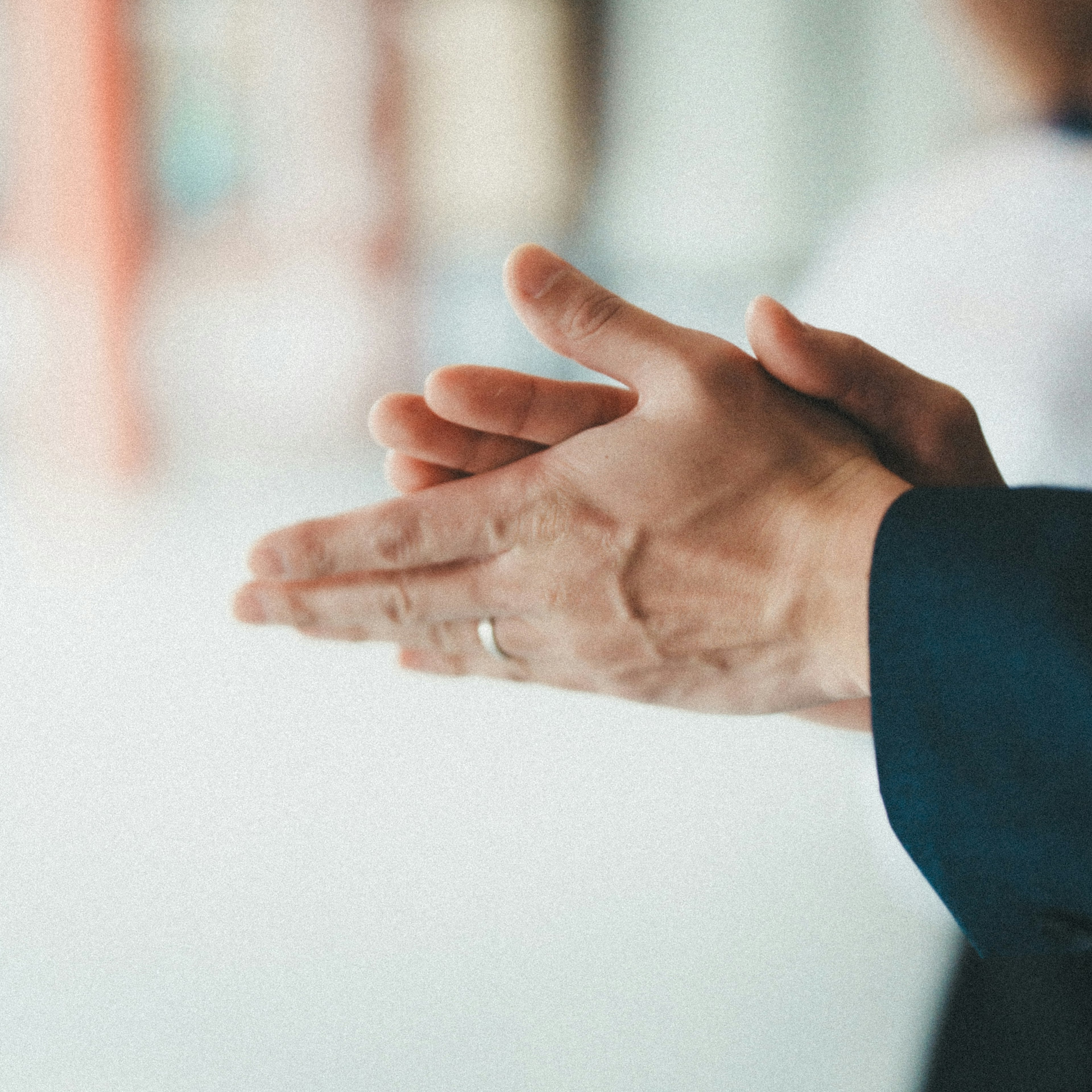 Close-up of a man's hands clapping wearing a suit