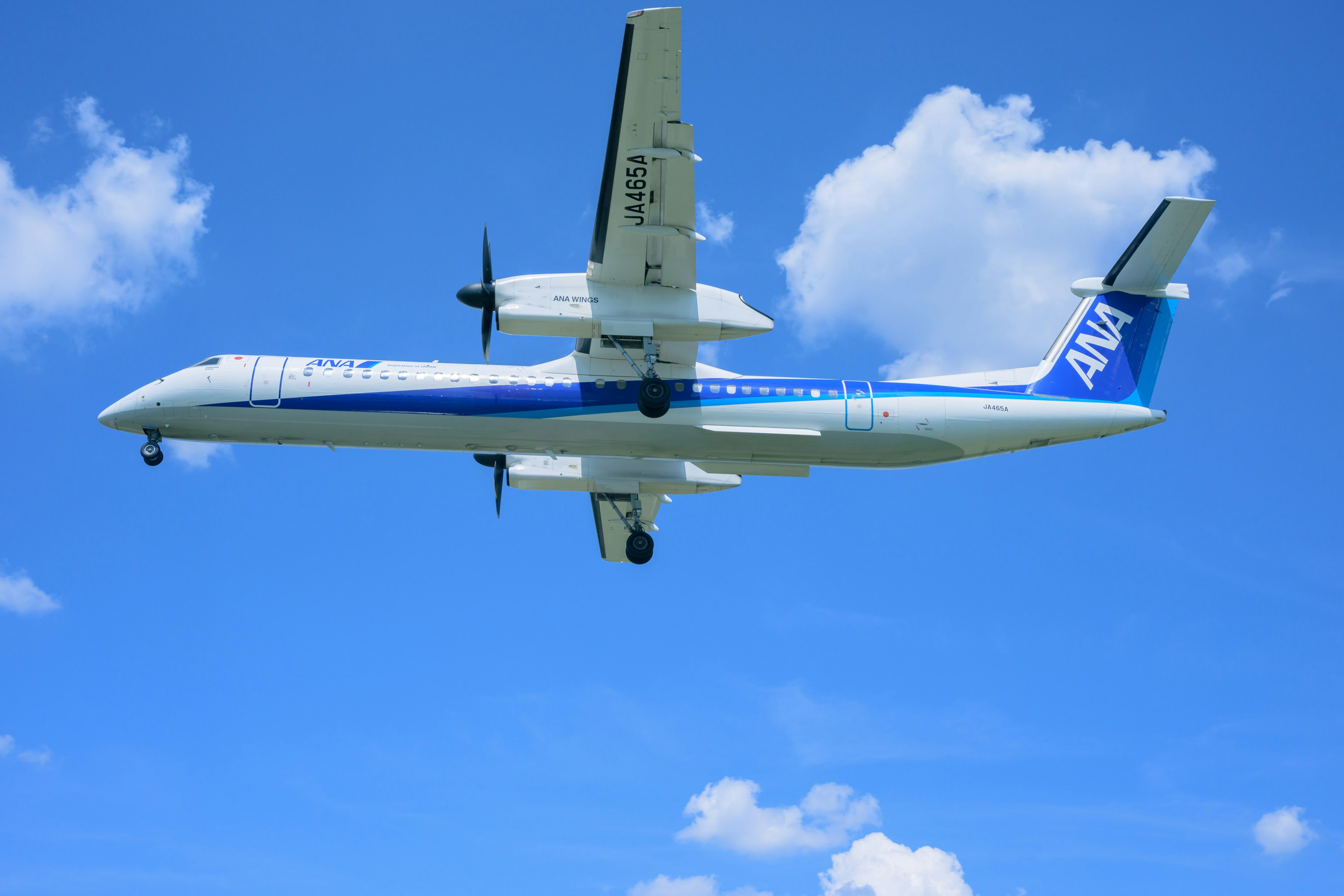 Aereo a elica ANA che vola sotto un cielo blu