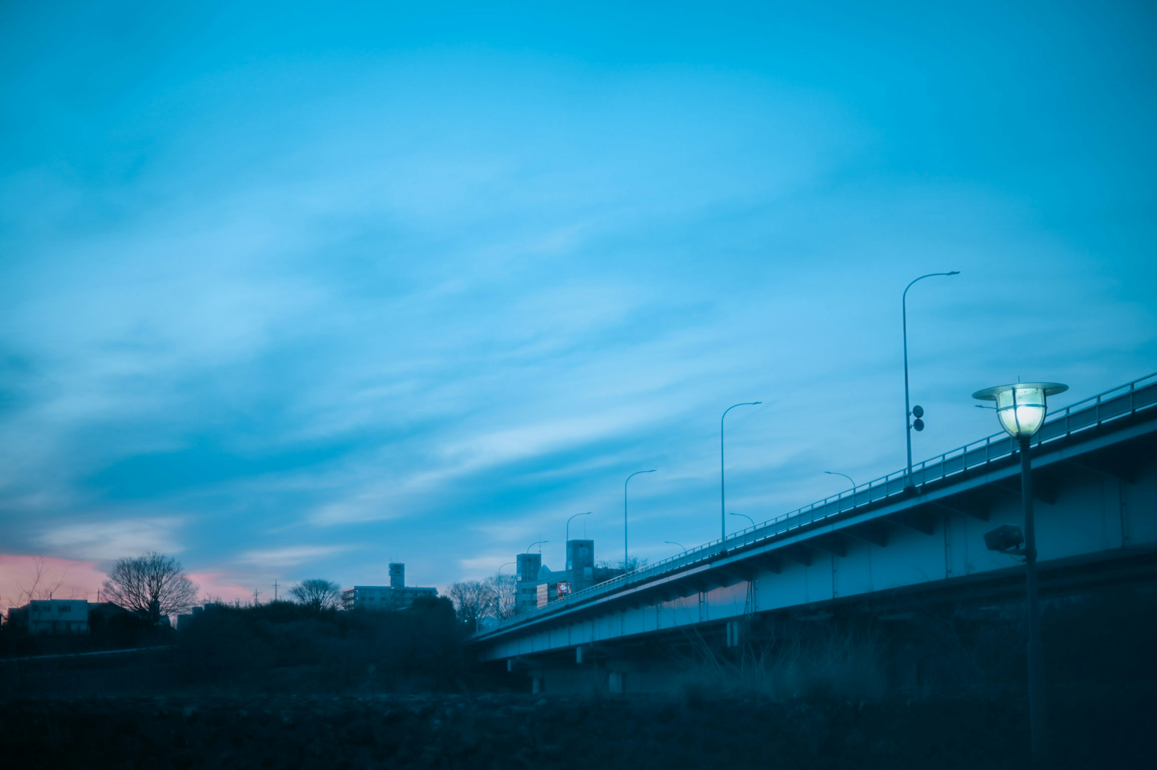 夕暮れ時の川と橋の風景 藍色の空と雲が広がる