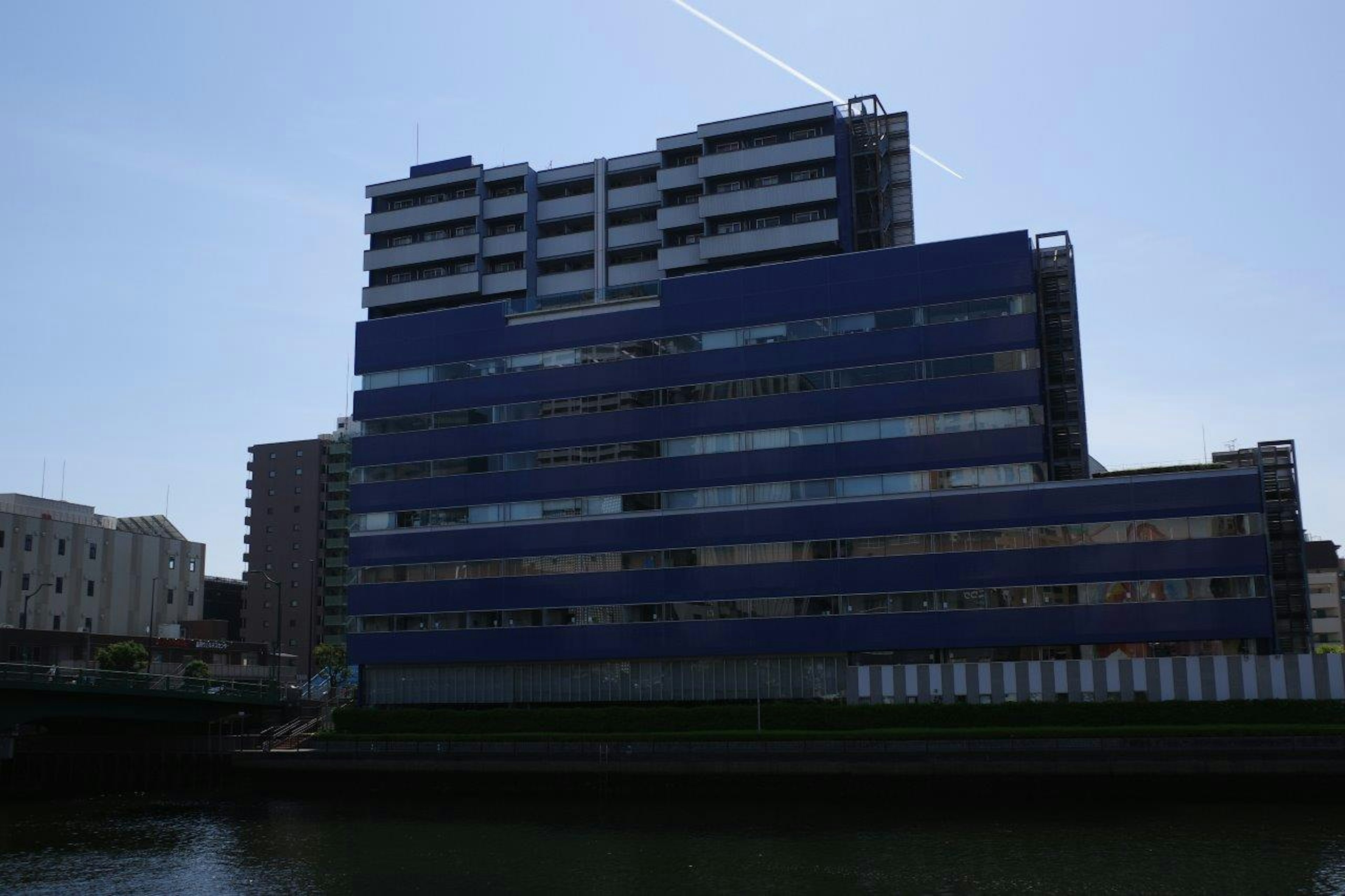 Bâtiment moderne avec façade bleue situé près de la rivière