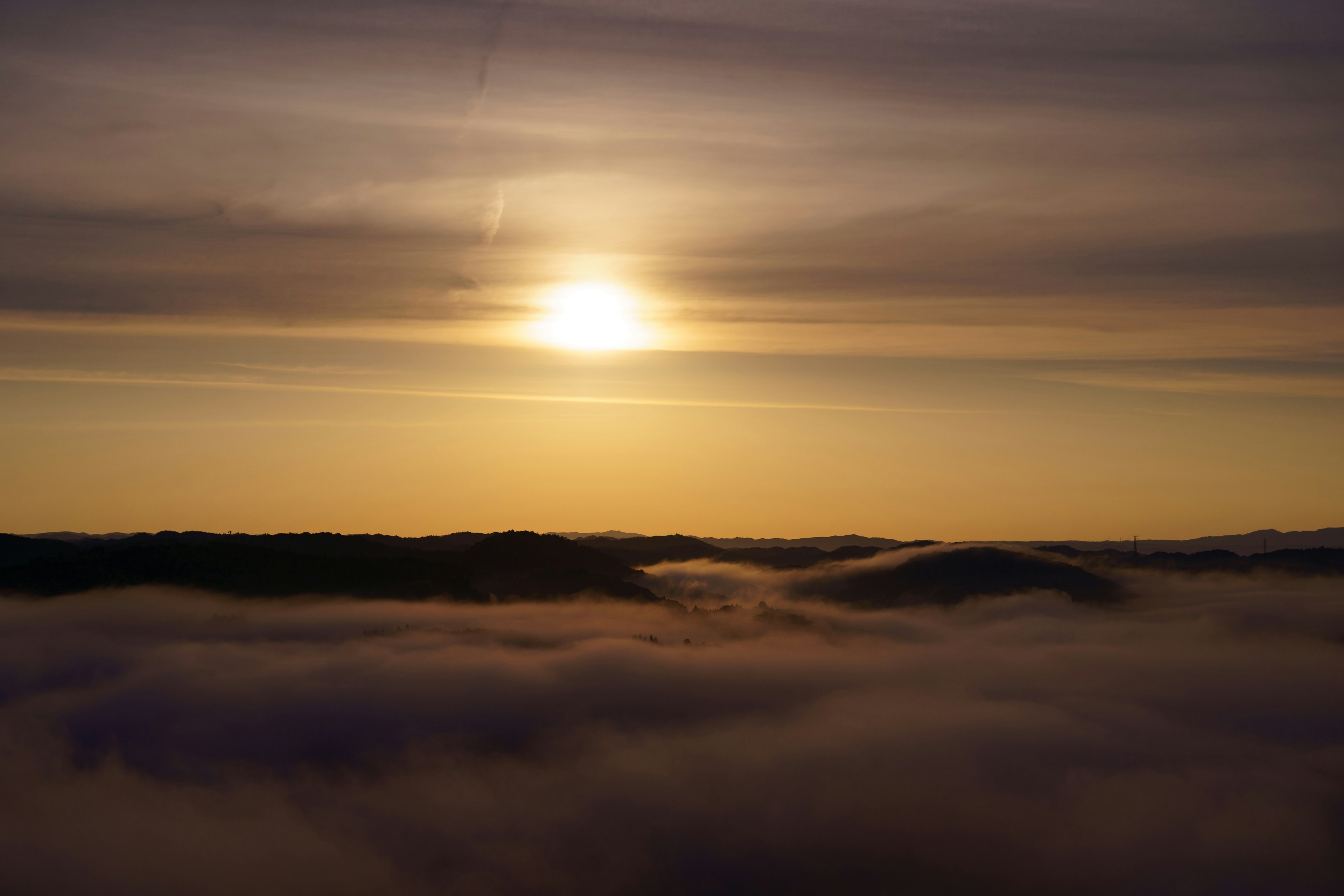 Matahari terbit di atas awan berkabut dengan nuansa lembut