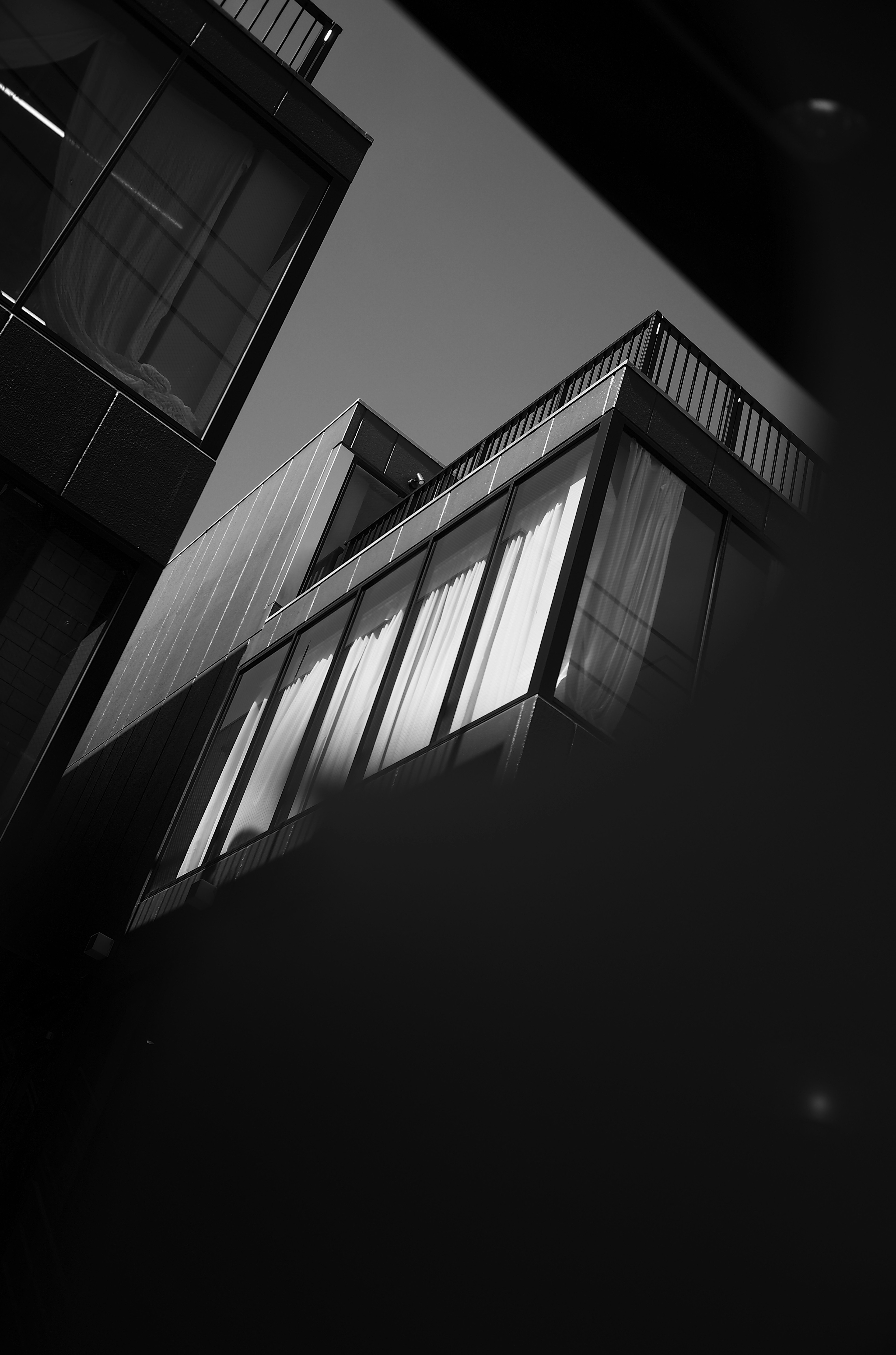 Black and white photo of modern buildings featuring reflective windows and geometric shapes