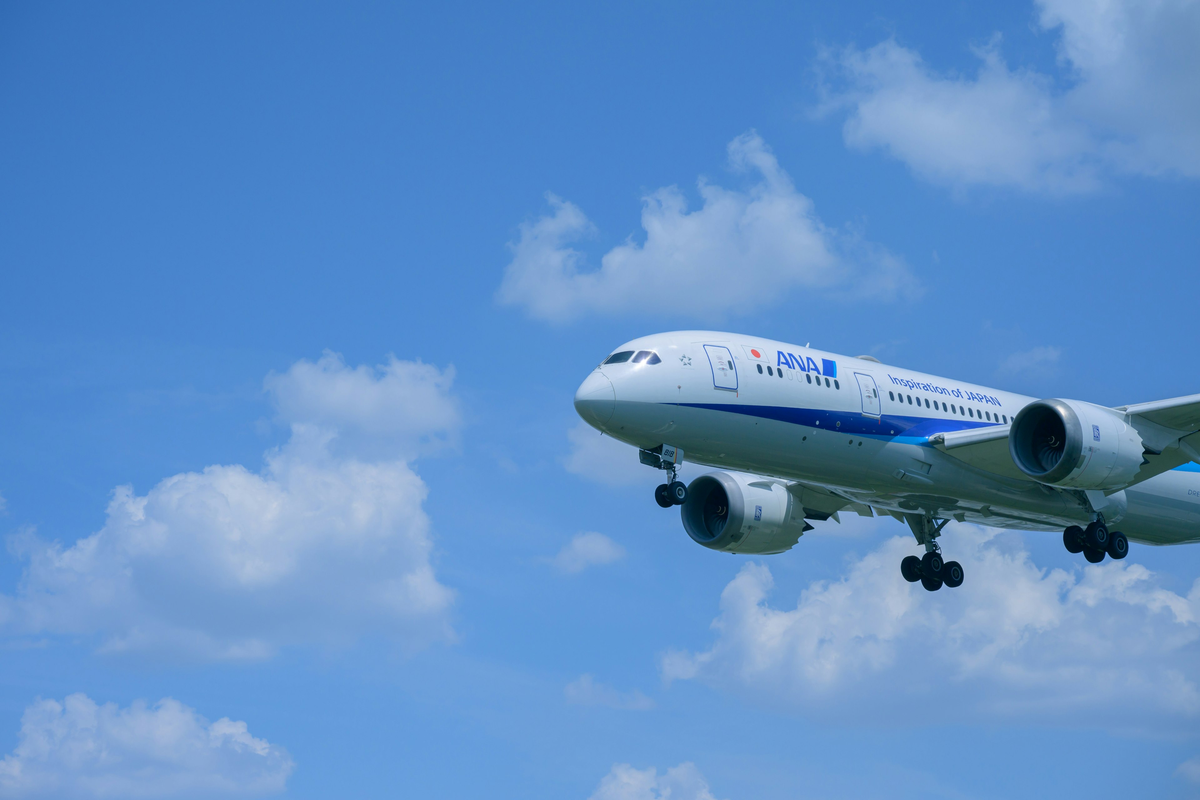 青空の下で飛行する旅客機の写真