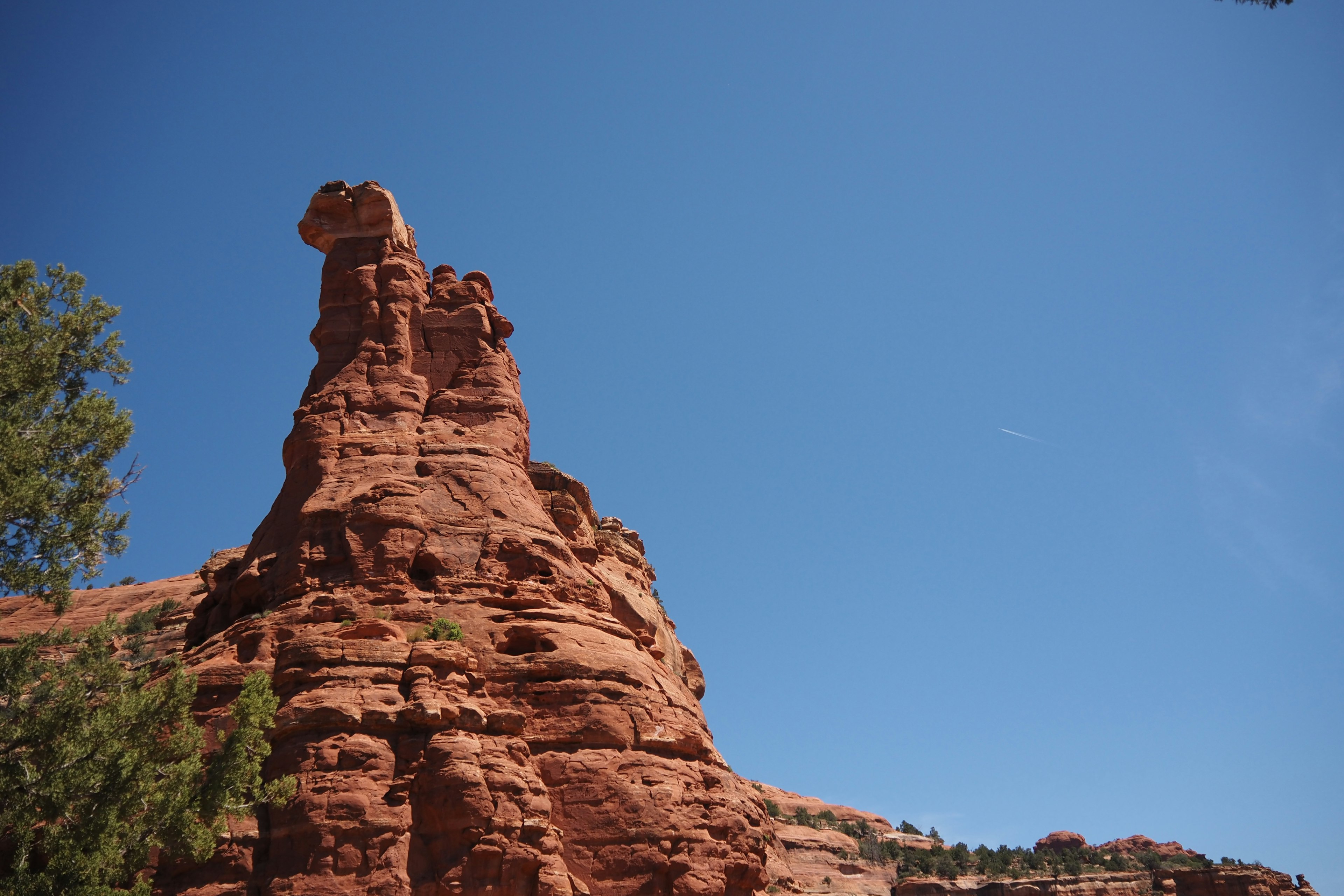 Distinctive rock formation against a blue sky with red hues