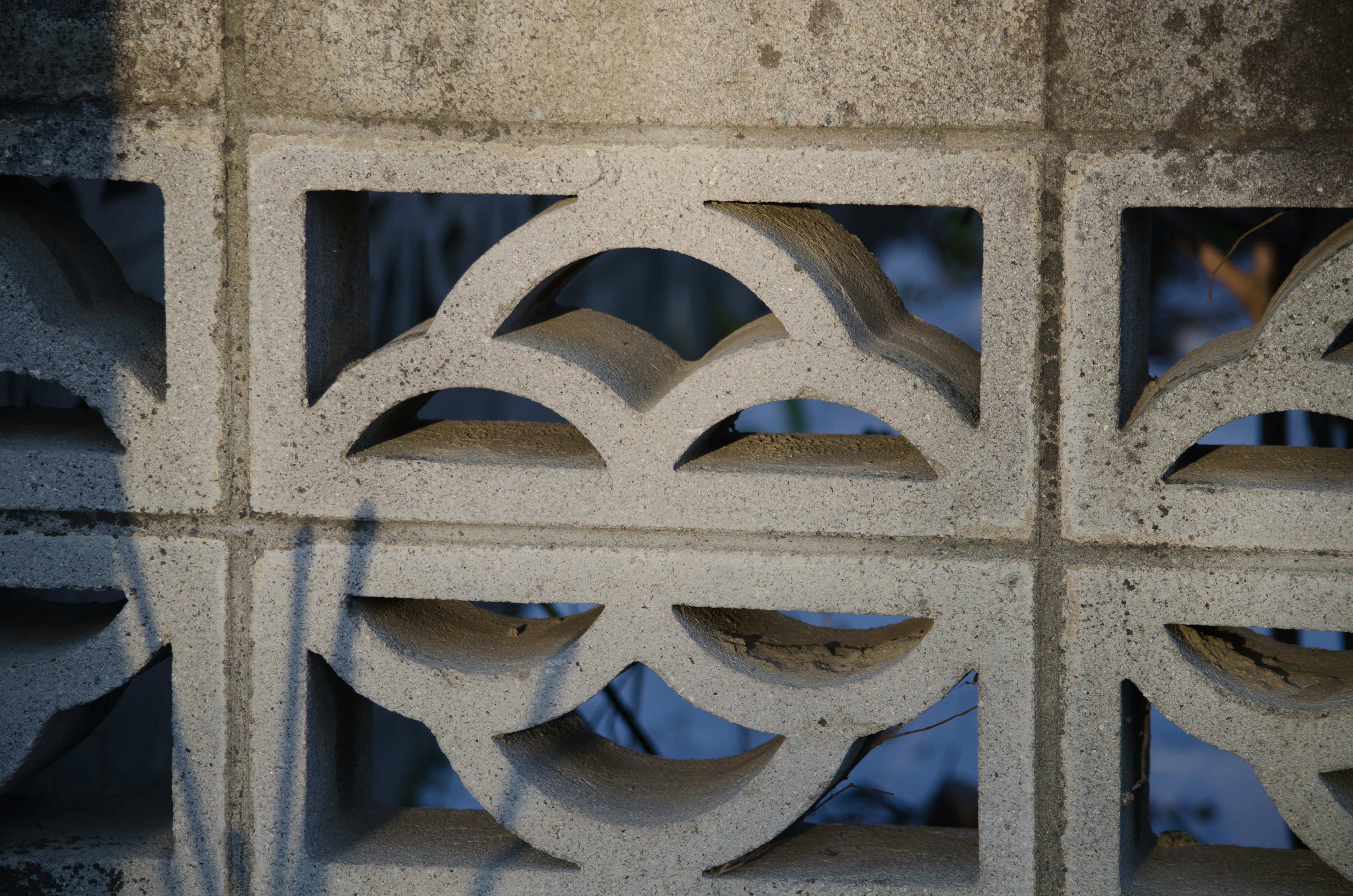 Primer plano de una pared de bloques de concreto decorativos con patrones curvos únicos