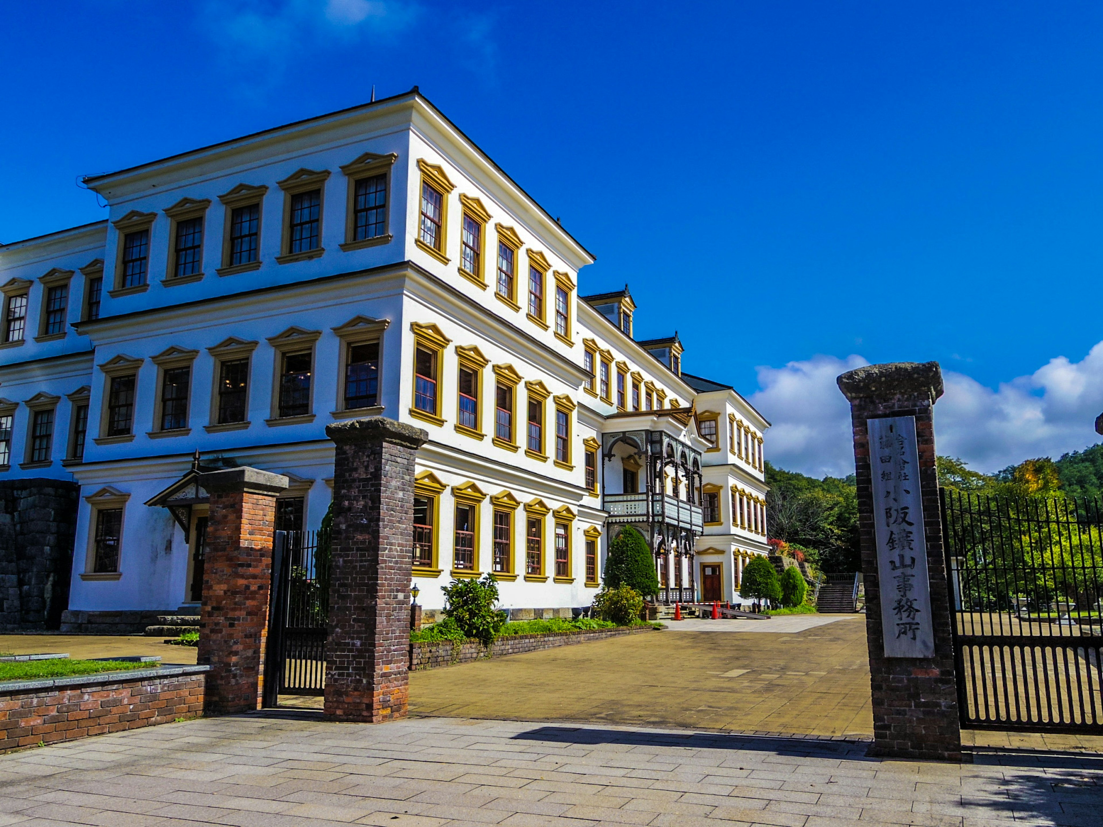 Historic building exterior with blue sky and green landscape