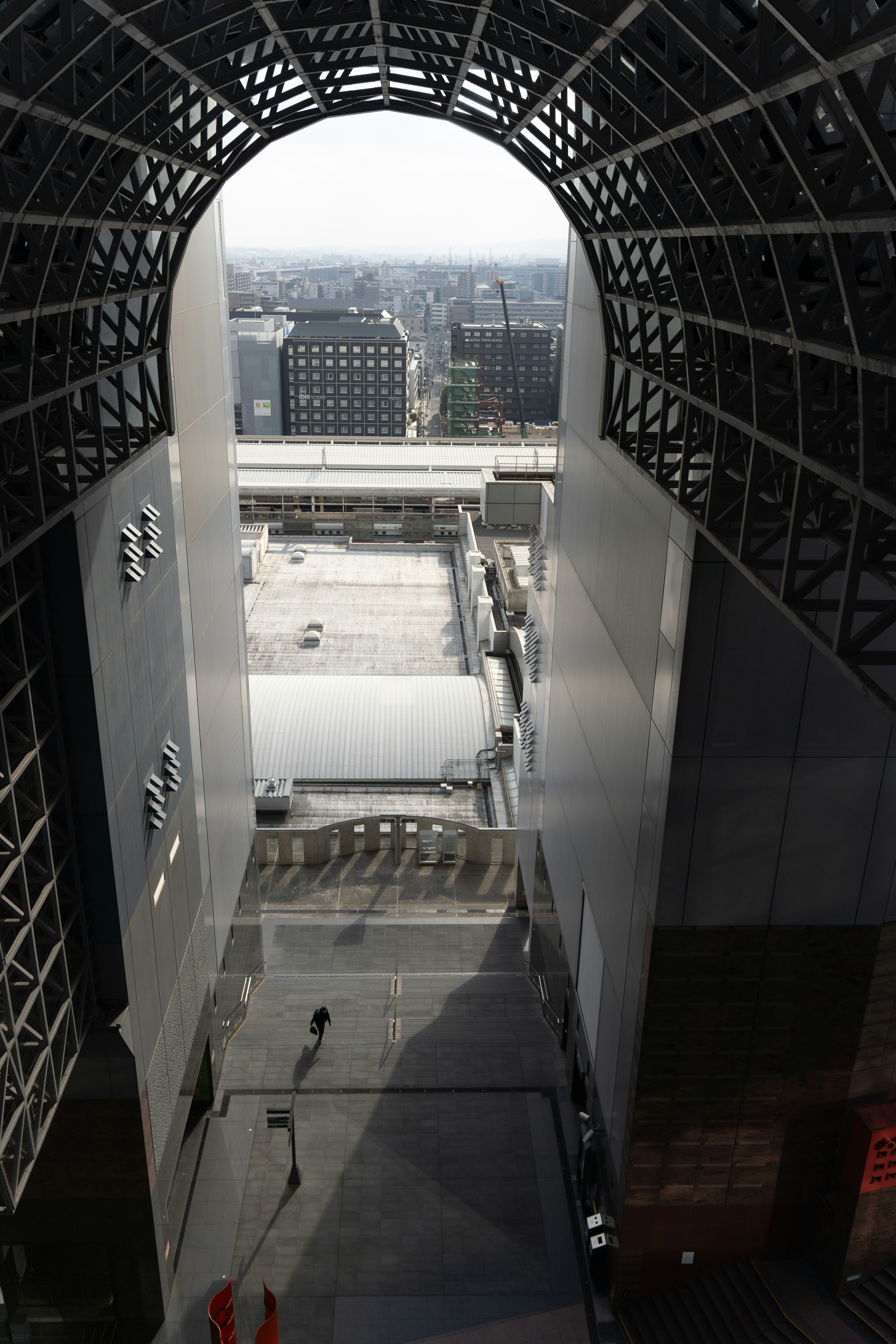 Vue de l'intérieur d'un bâtiment moderne avec une large ouverture en arc regardant à l'extérieur