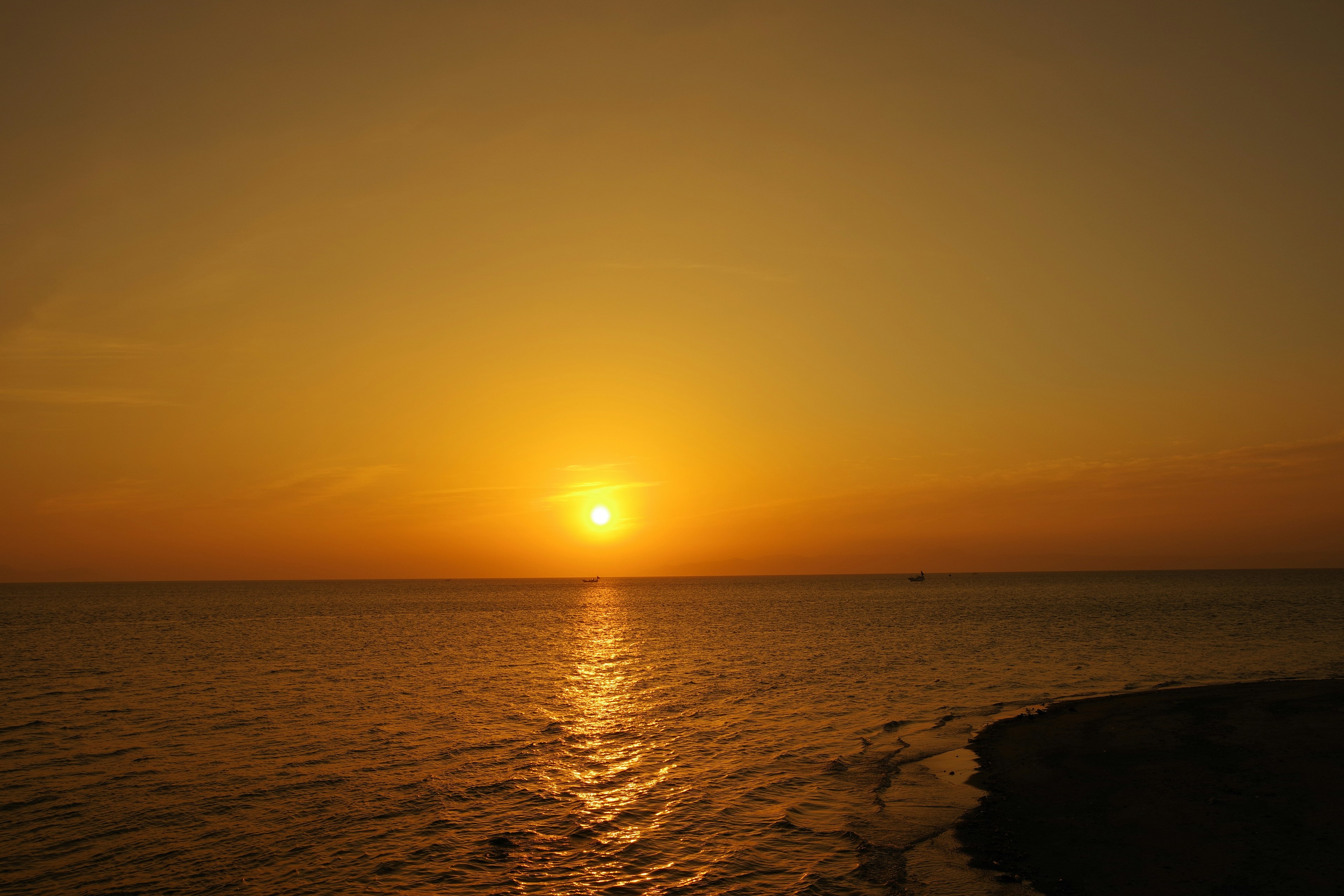 Wunderschöner Sonnenuntergang über dem Ozean mit orangefarbenem Himmel und reflektierendem Wasser