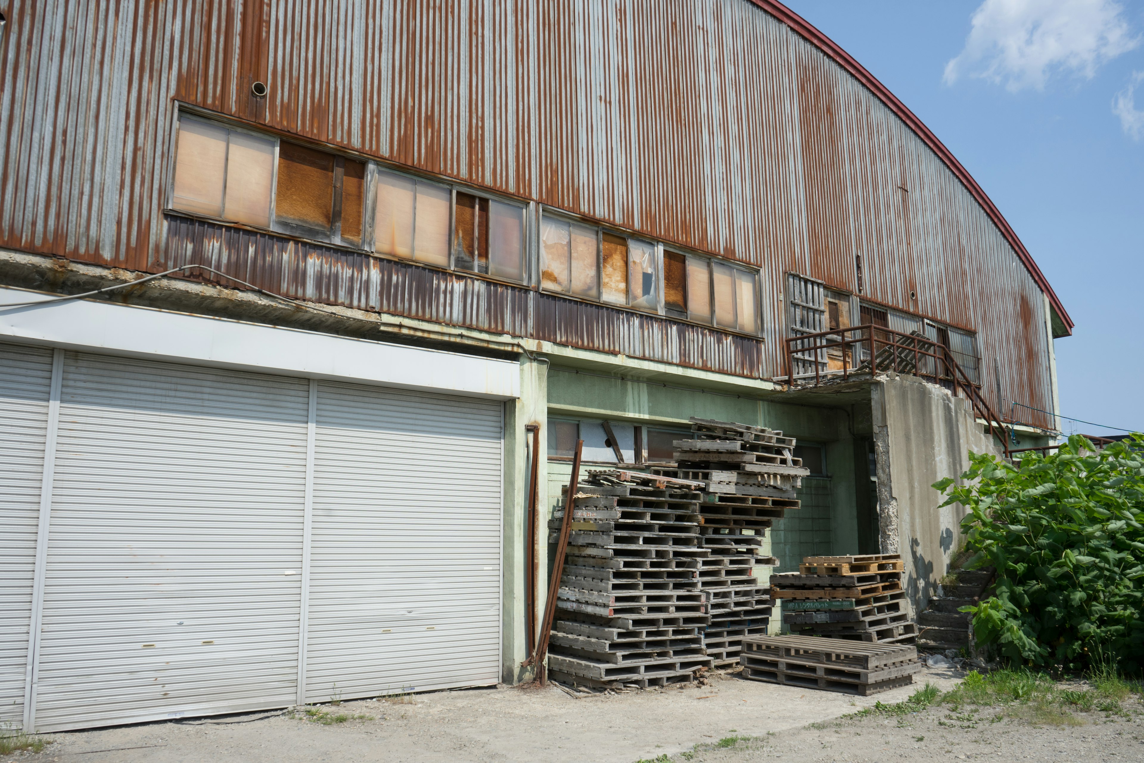 Exterior of an old warehouse with stacked pallets