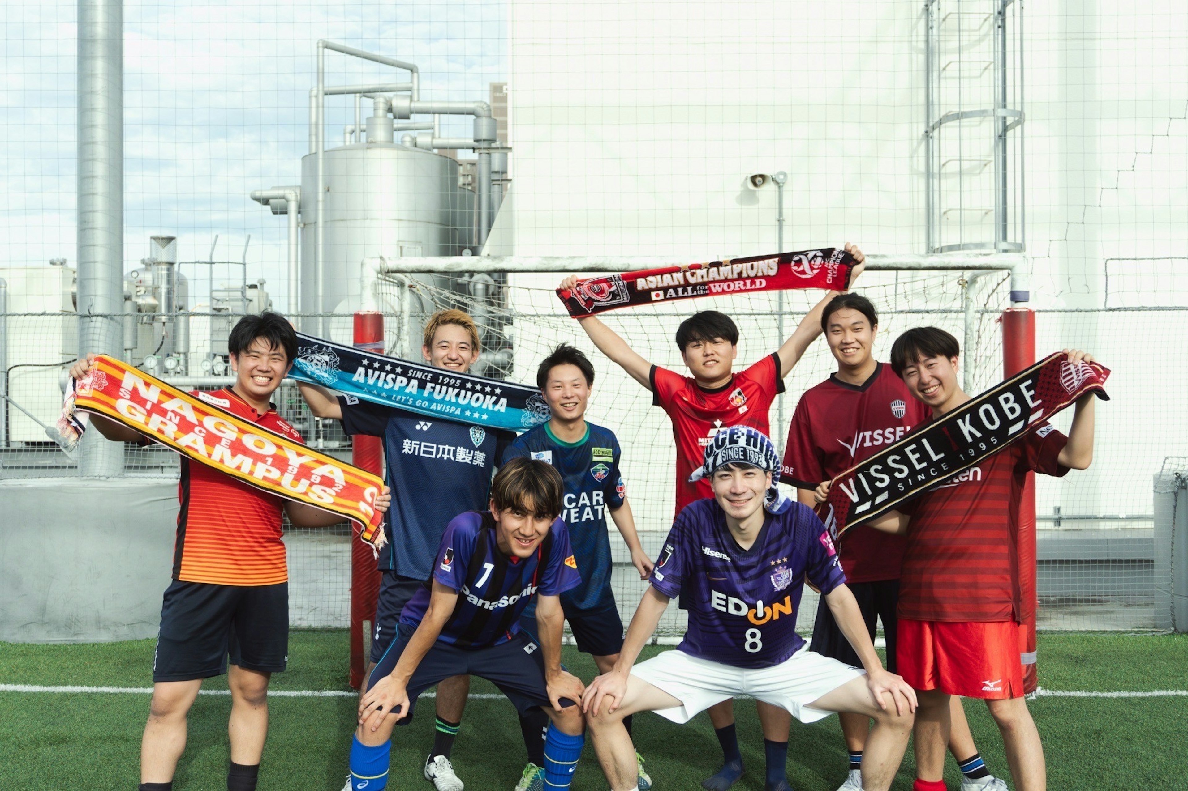 Photo de groupe d'amateurs de football portant des maillots colorés et tenant des écharpes