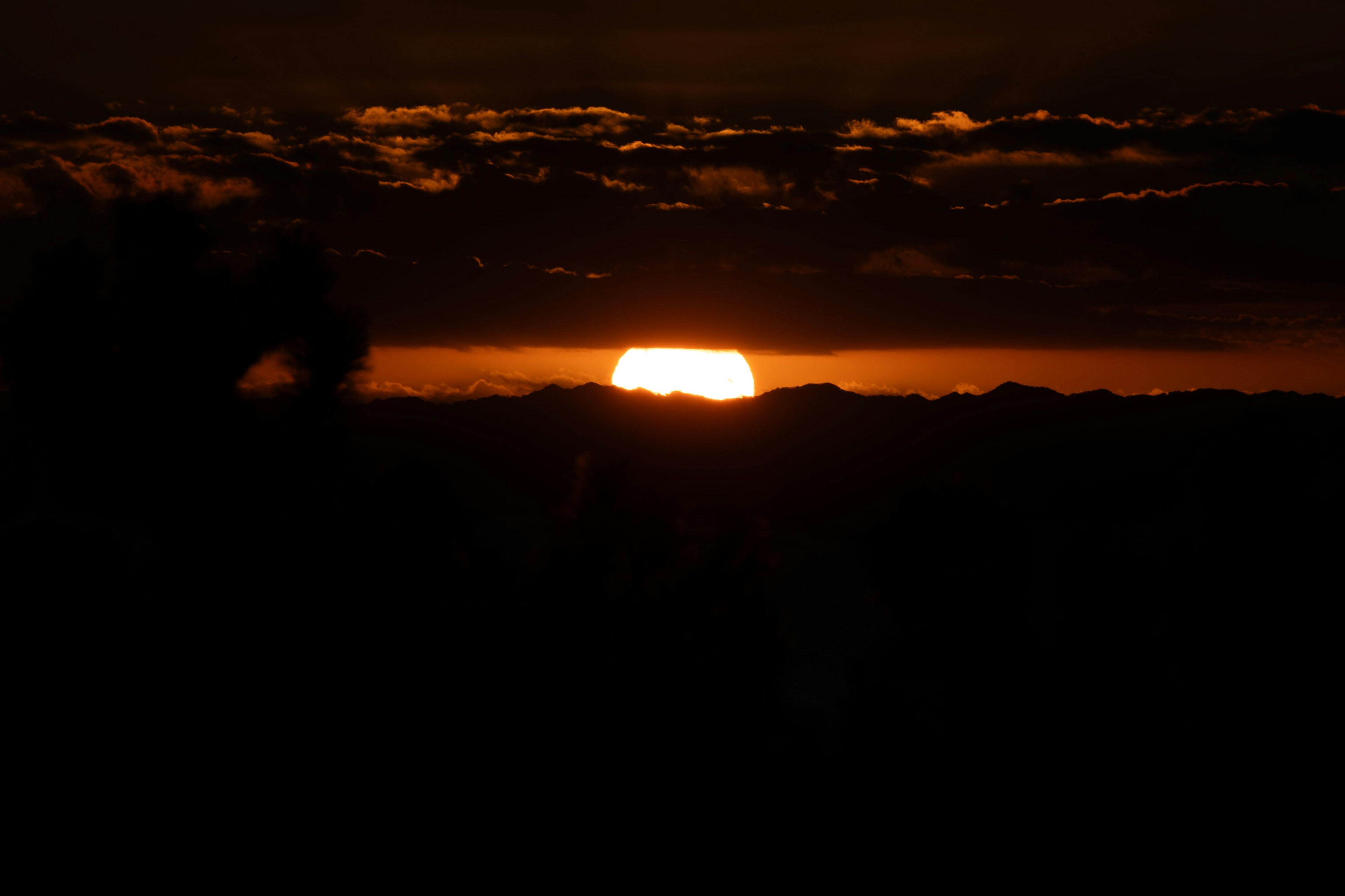 夕日が山の向こうに沈む美しい風景