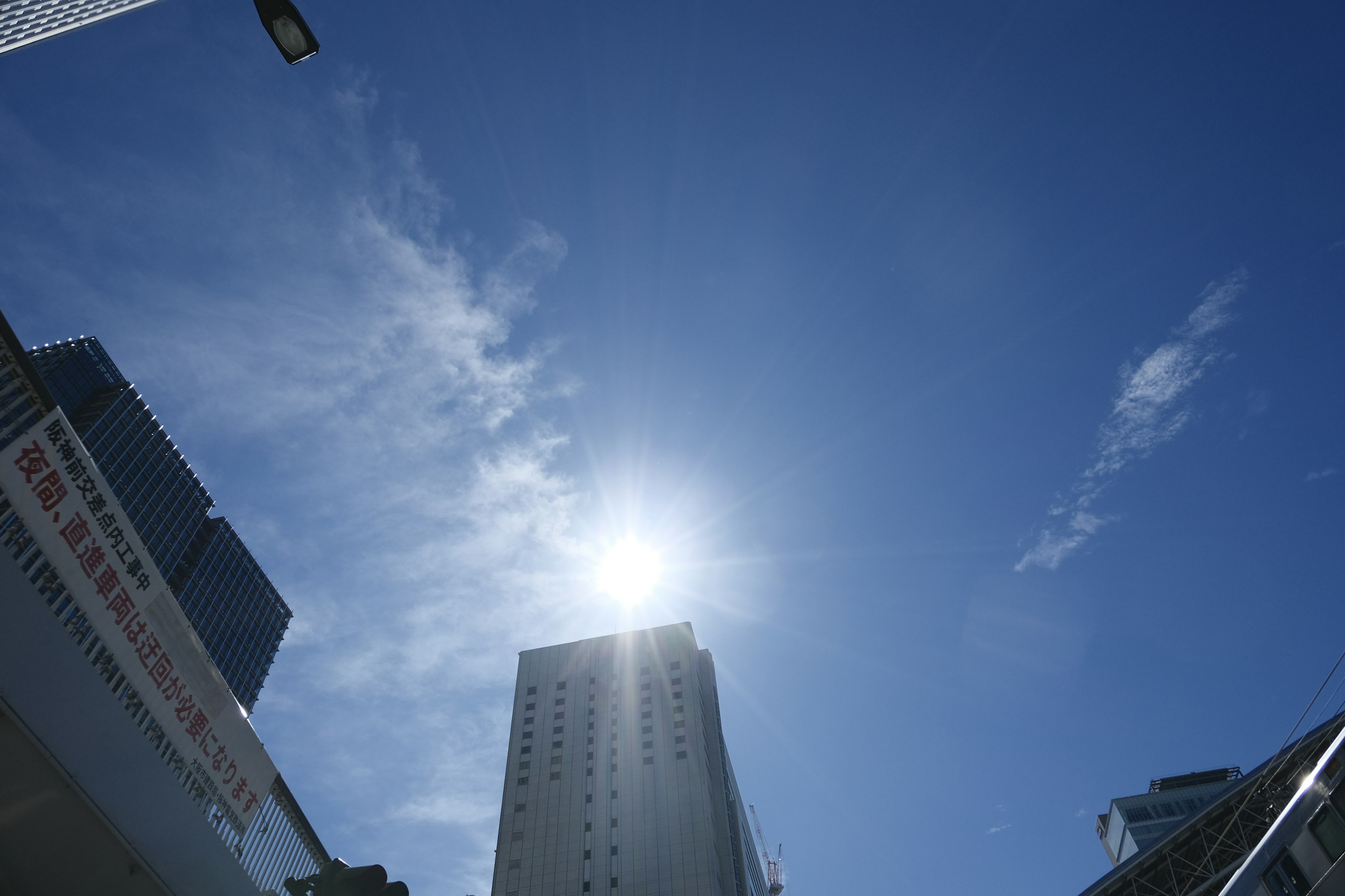 Alto grattacielo sotto un cielo blu chiaro con sole luminoso