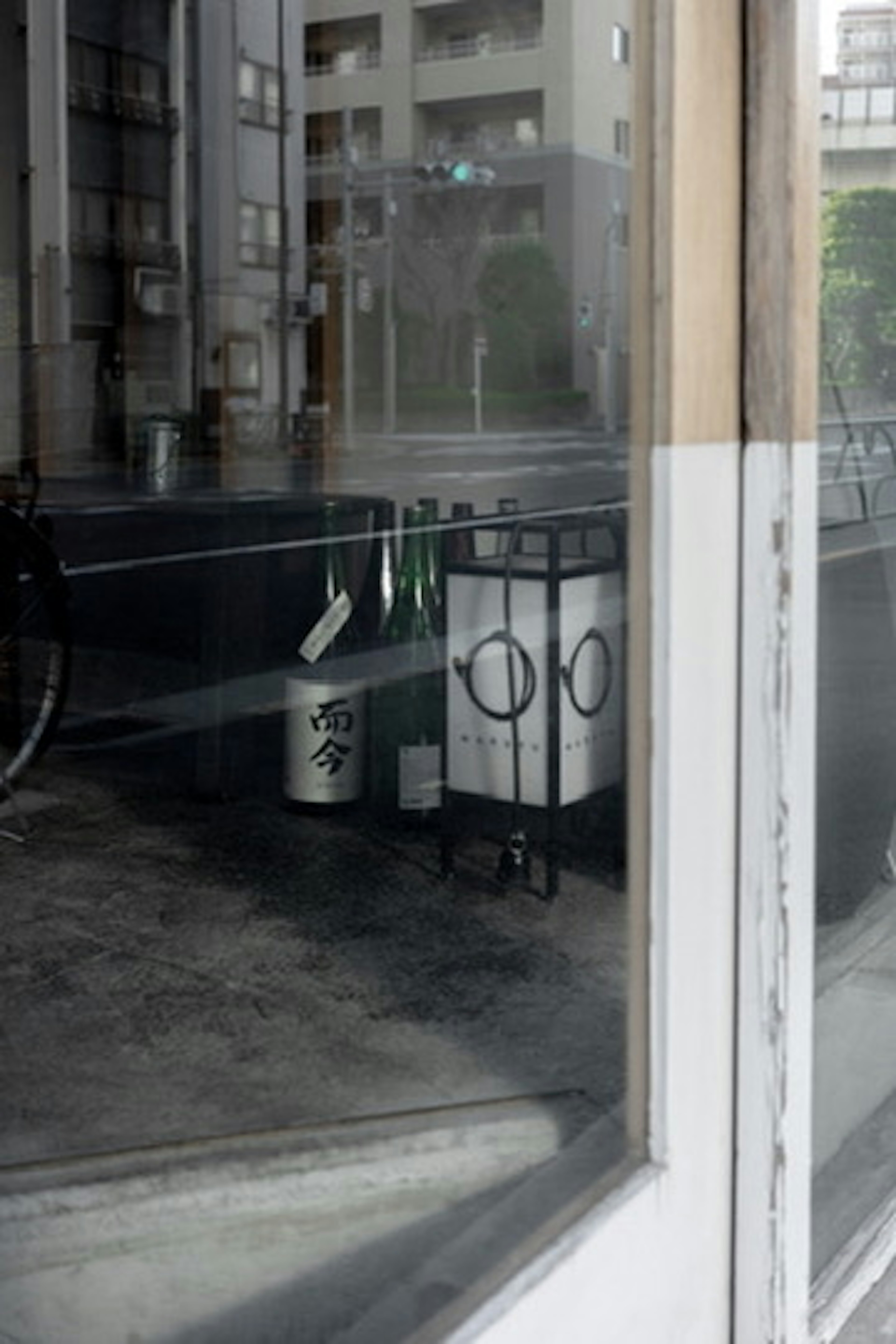 Reflection of cityscape in glass with bottles on a table