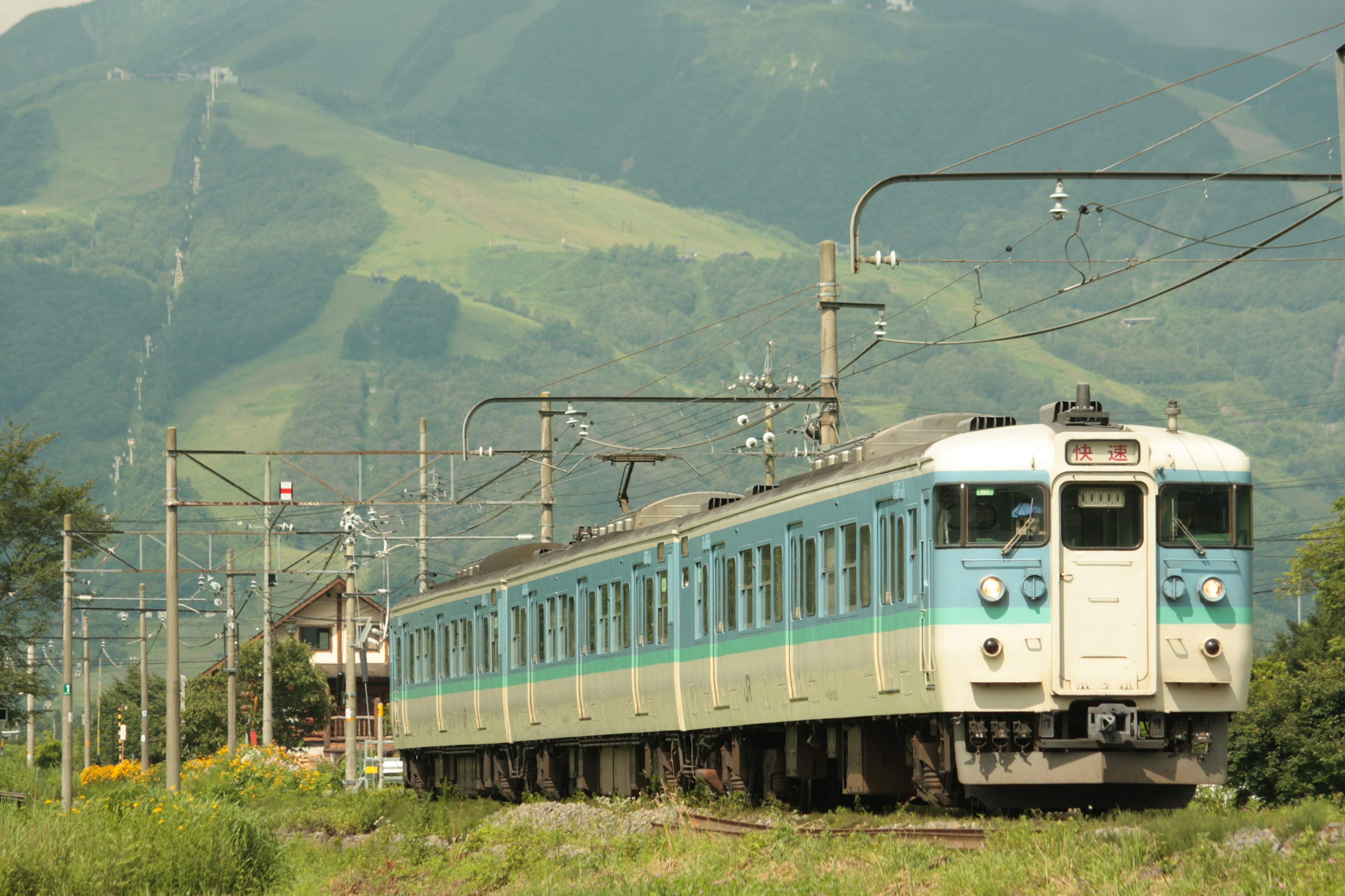 Tren azul circulando contra un fondo montañoso