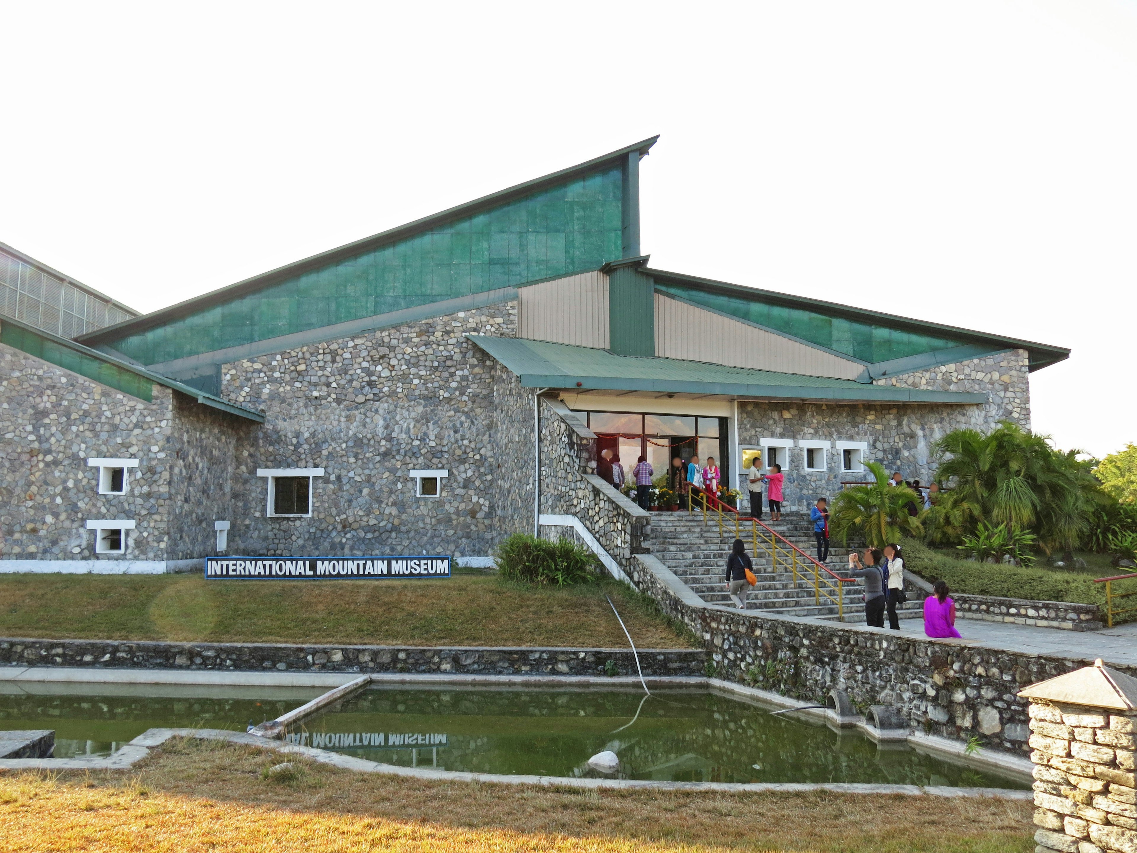 Exterior of International Museum featuring stone architecture and green roof with people entering and exiting