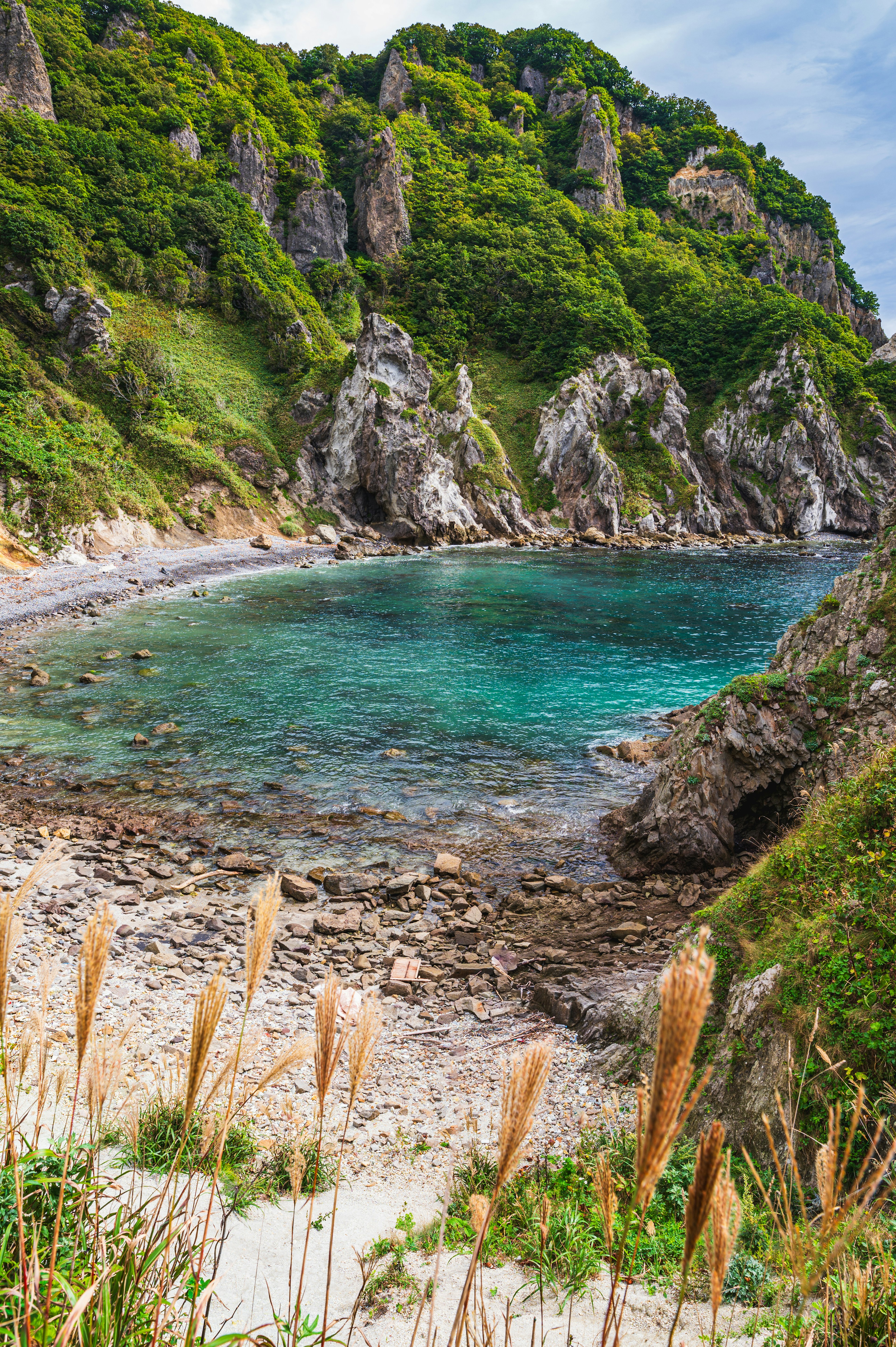 青い海と緑の丘に囲まれた美しい入り江の風景