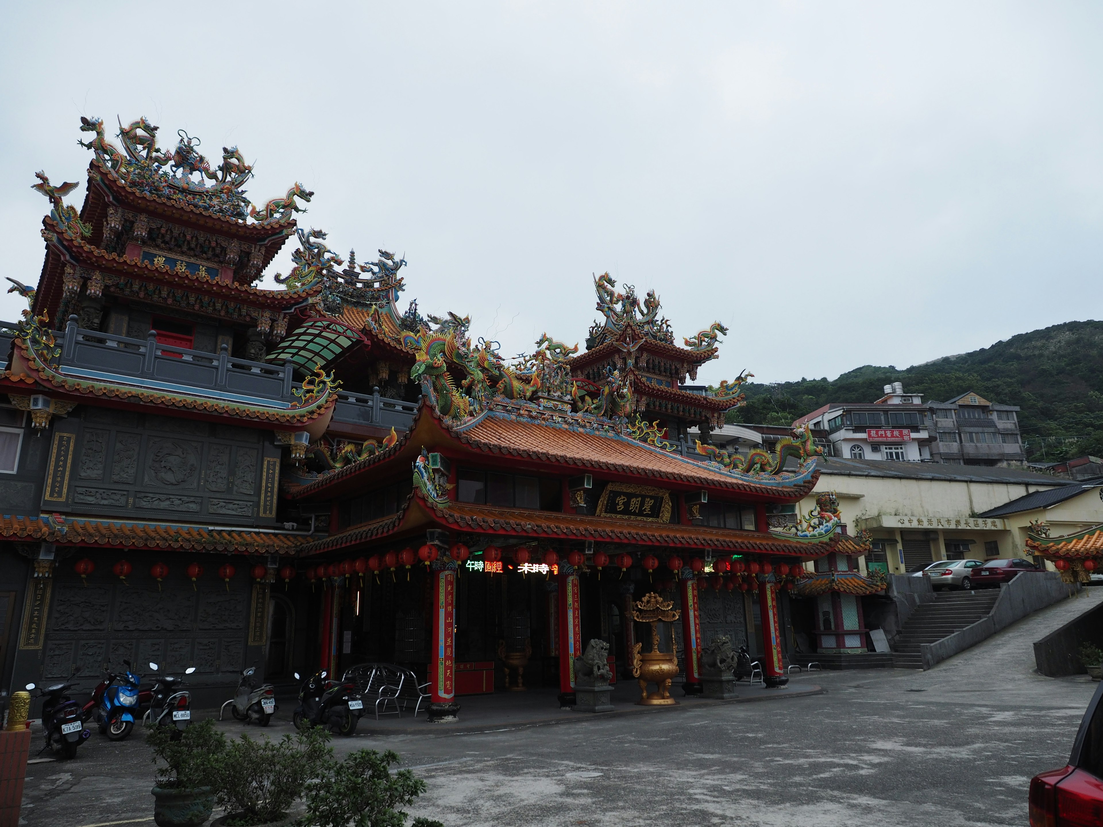 Extérieur d'un temple traditionnel avec des toits colorés et des bâtiments environnants