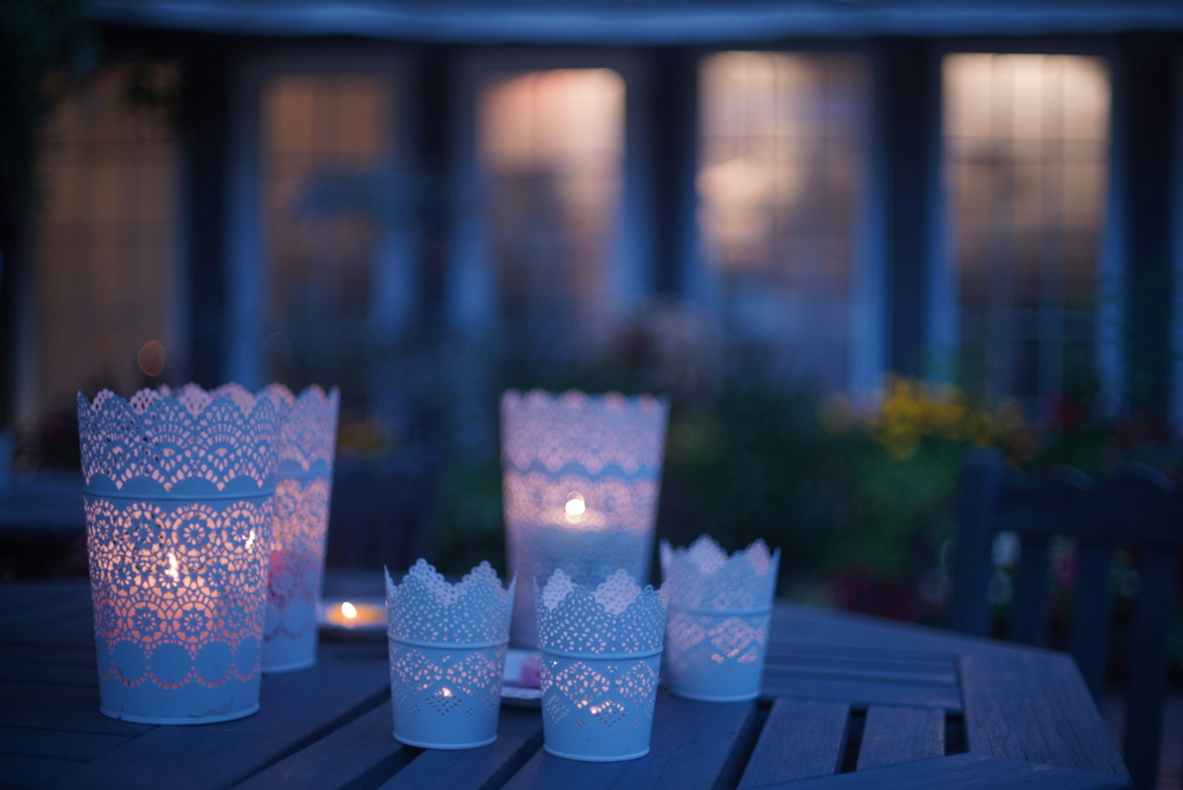 Des porte-bougies faits main brillent doucement sur une table avec un fond sombre