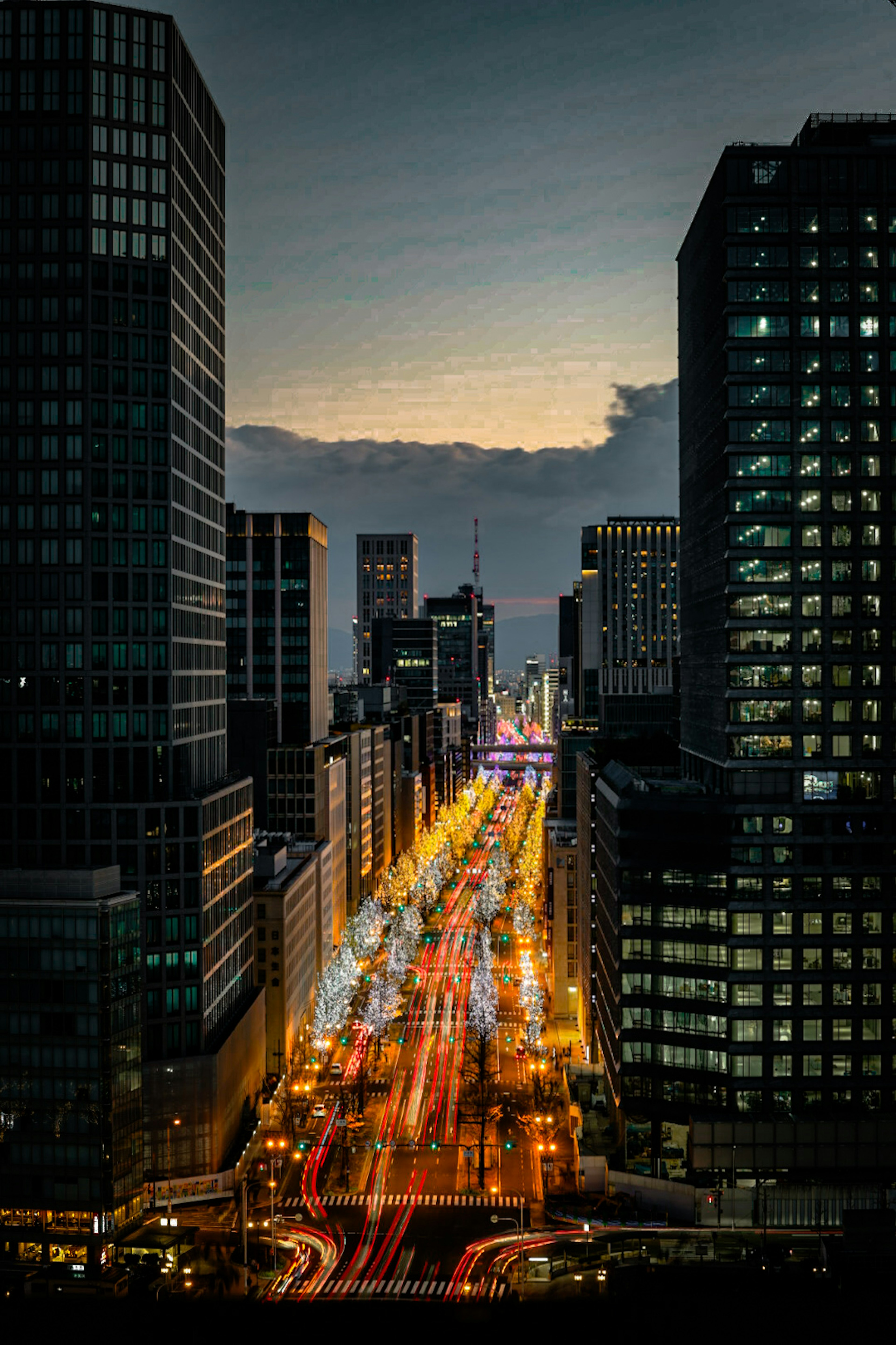 Cityscape at dusk featuring skyscrapers and illuminated streets