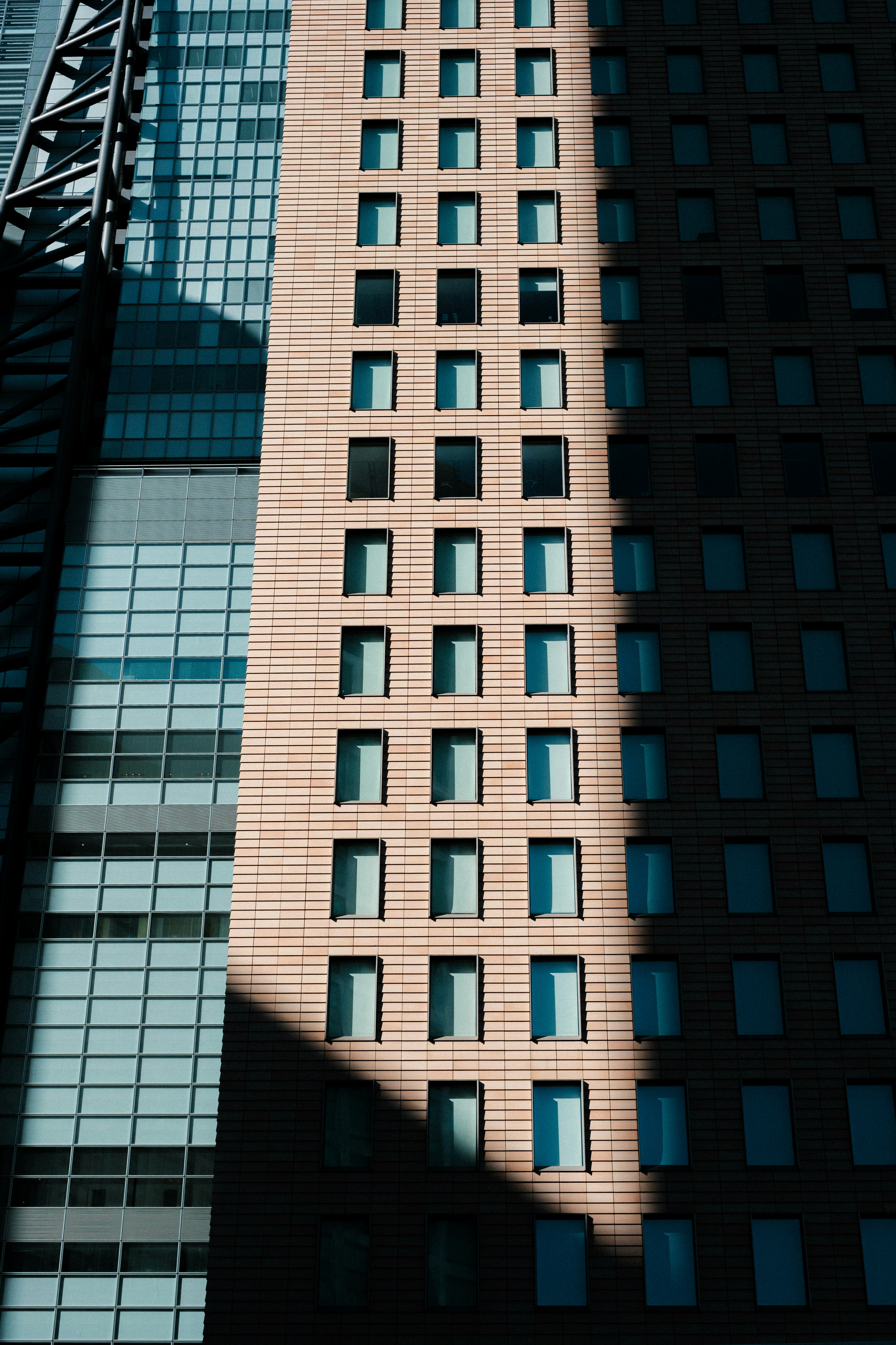 Façade d'un gratte-ciel avec des ombres et des motifs de fenêtres