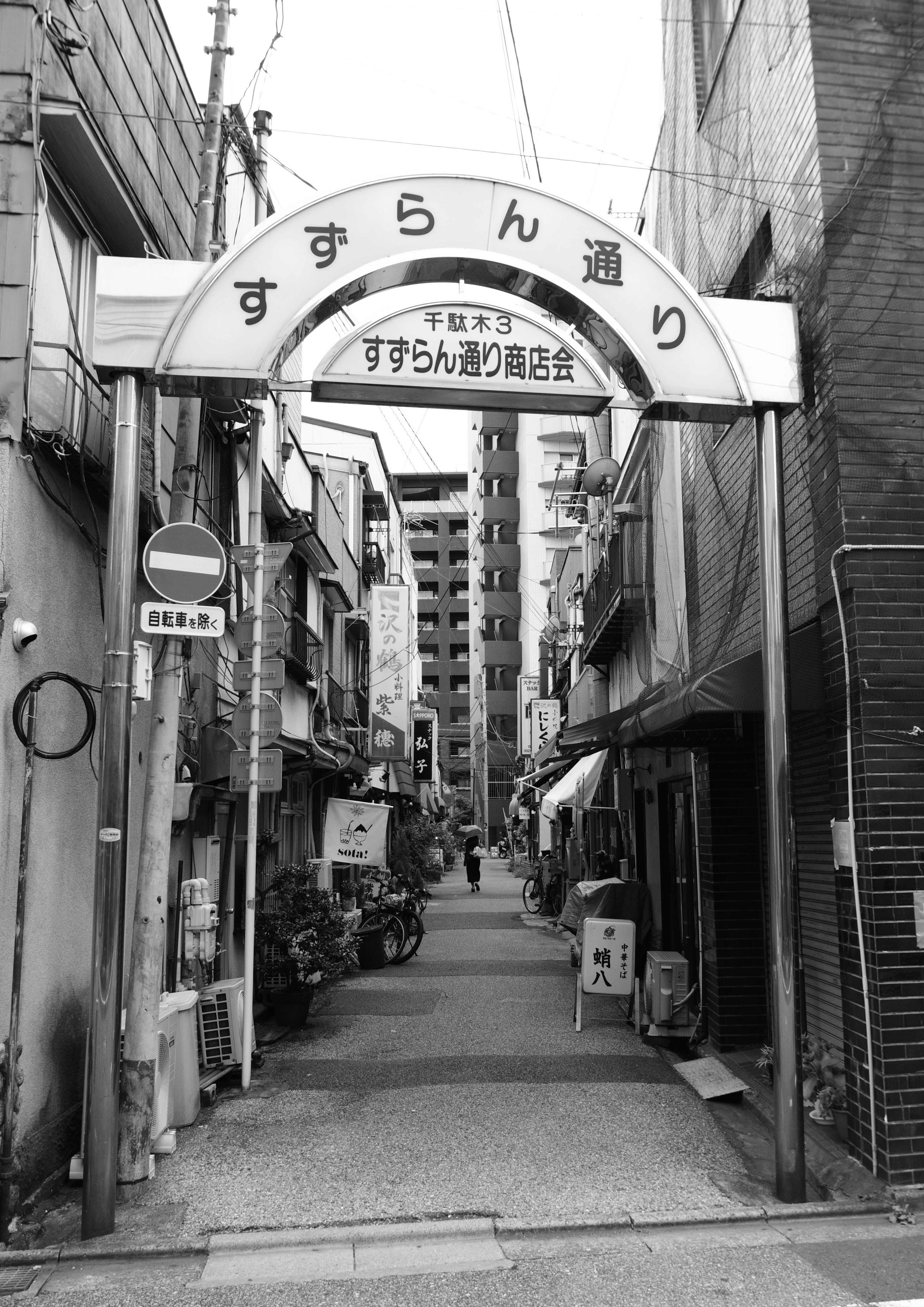 Archway sign of Suzuran Street with a narrow alley view