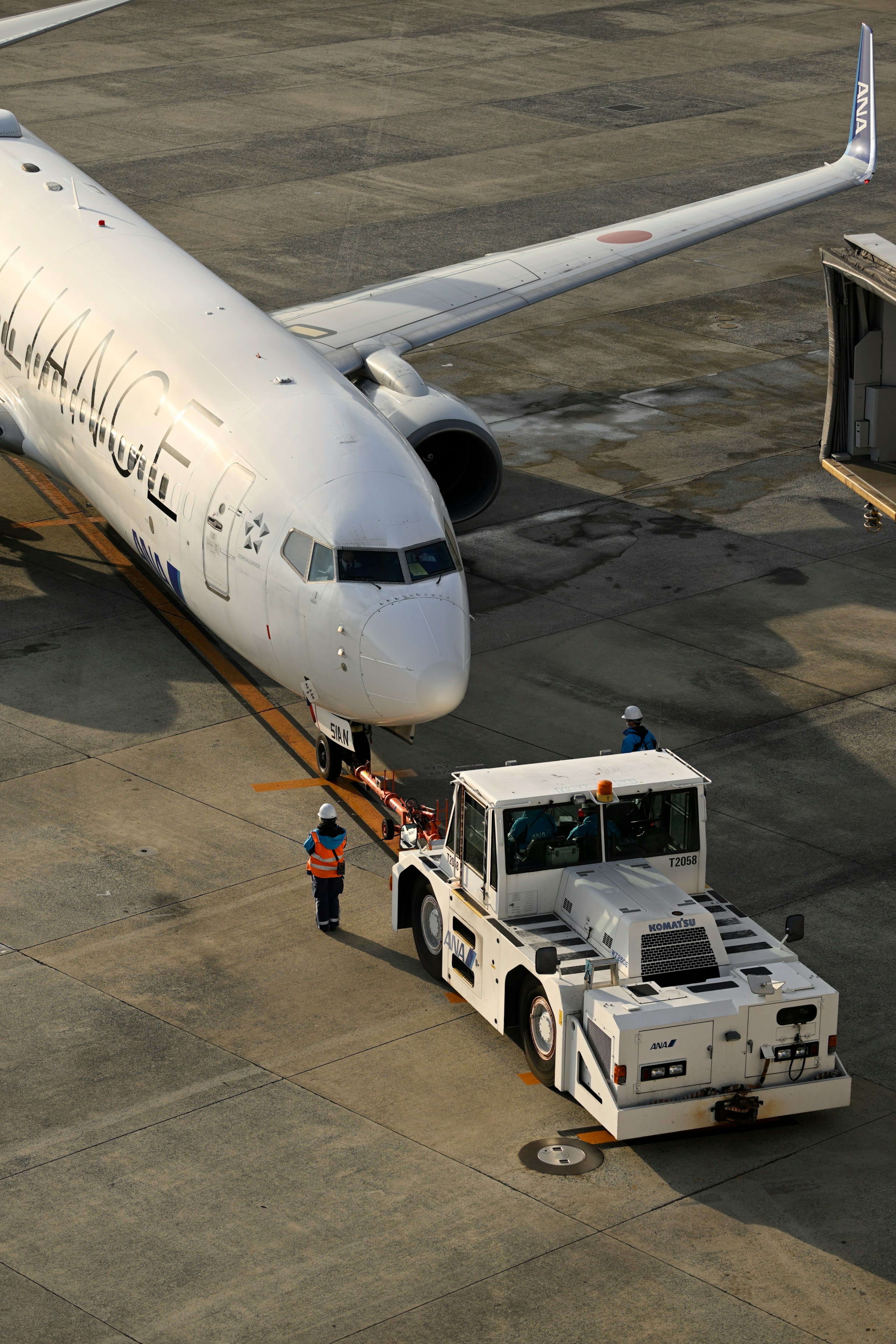 Flugzeug wird von einem Bodenfahrzeug am Flughafen geschleppt