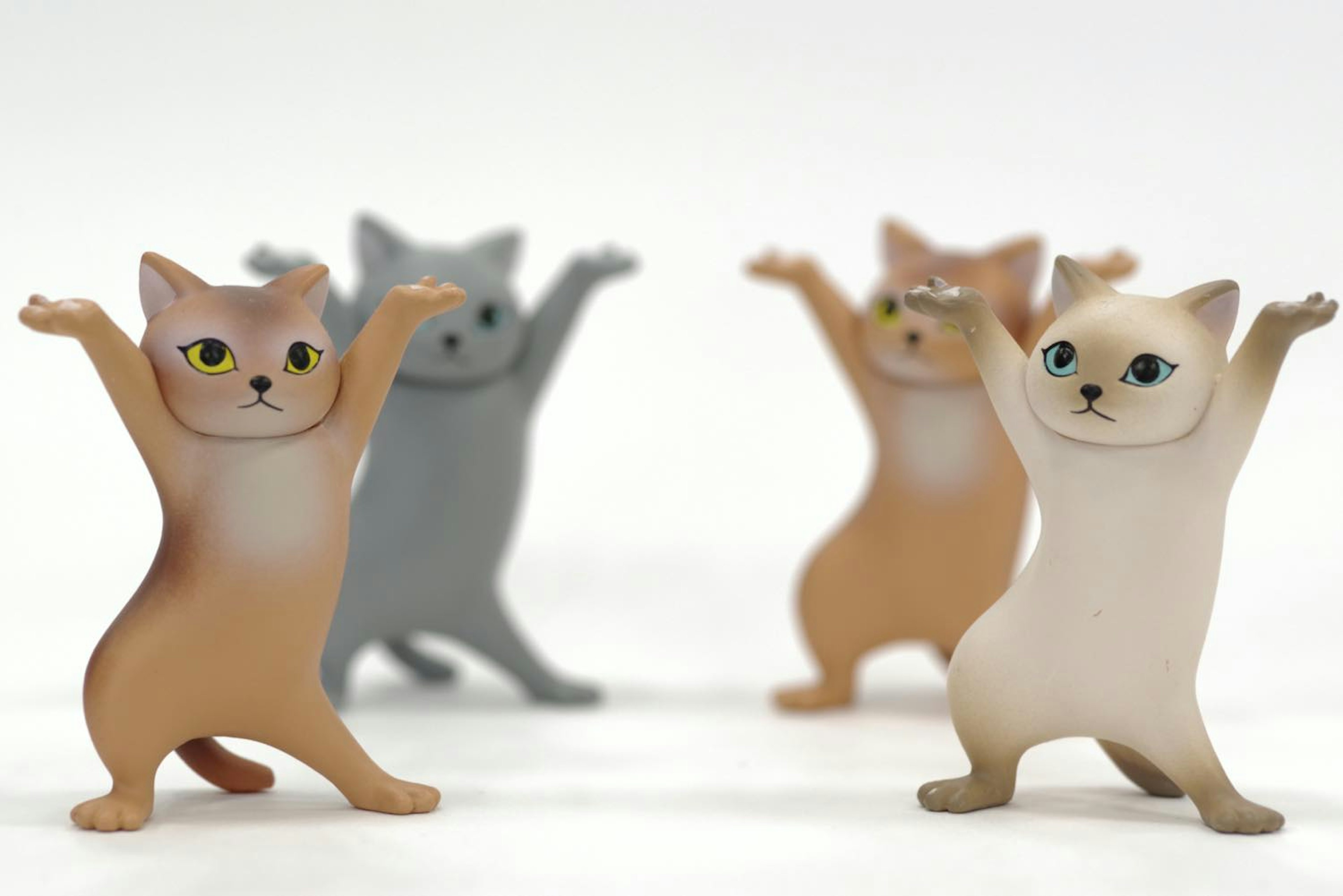 Cute cat figurines with raised arms in various colors