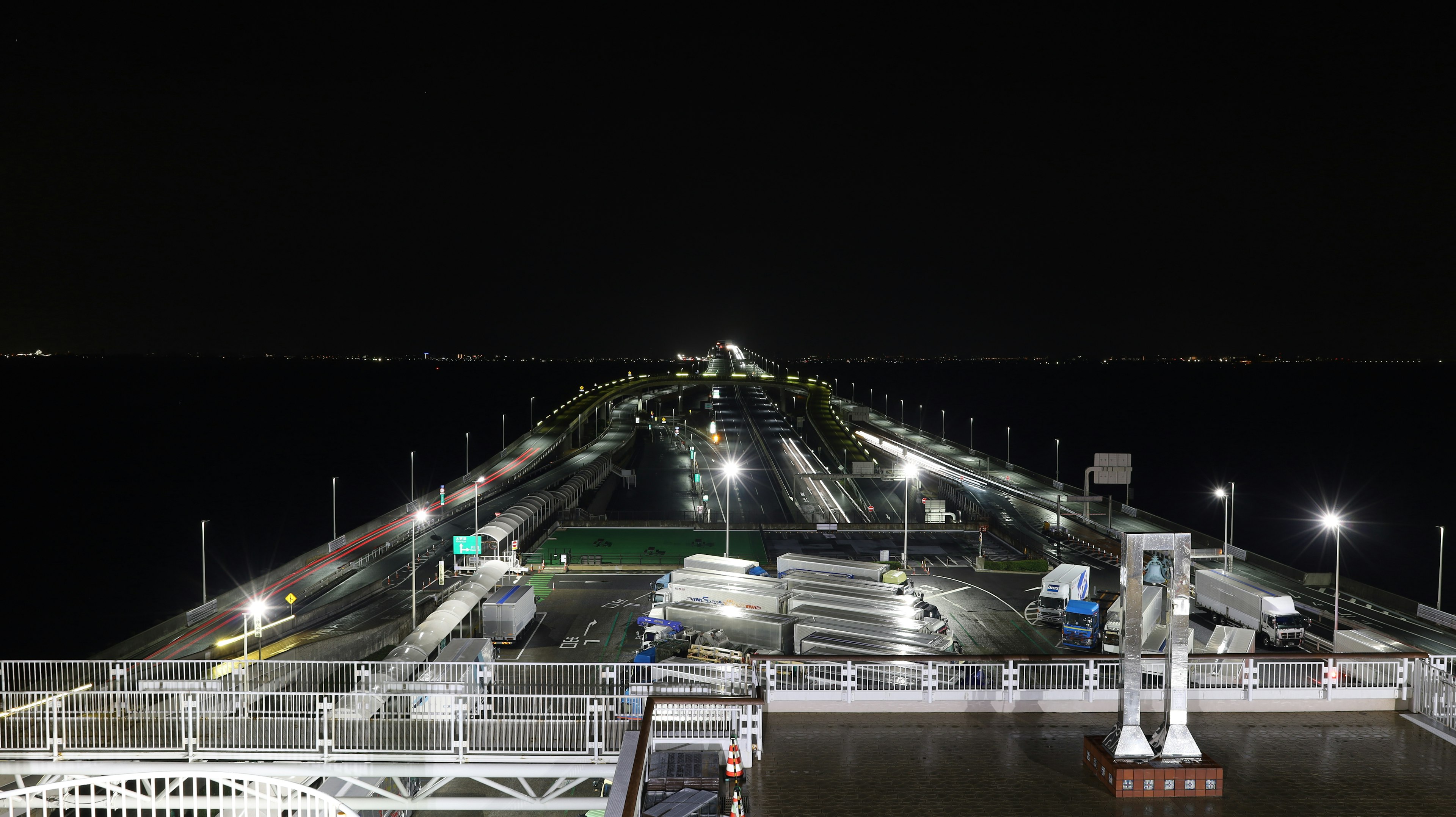 Bright roadway and traffic scene leading to the sea at night