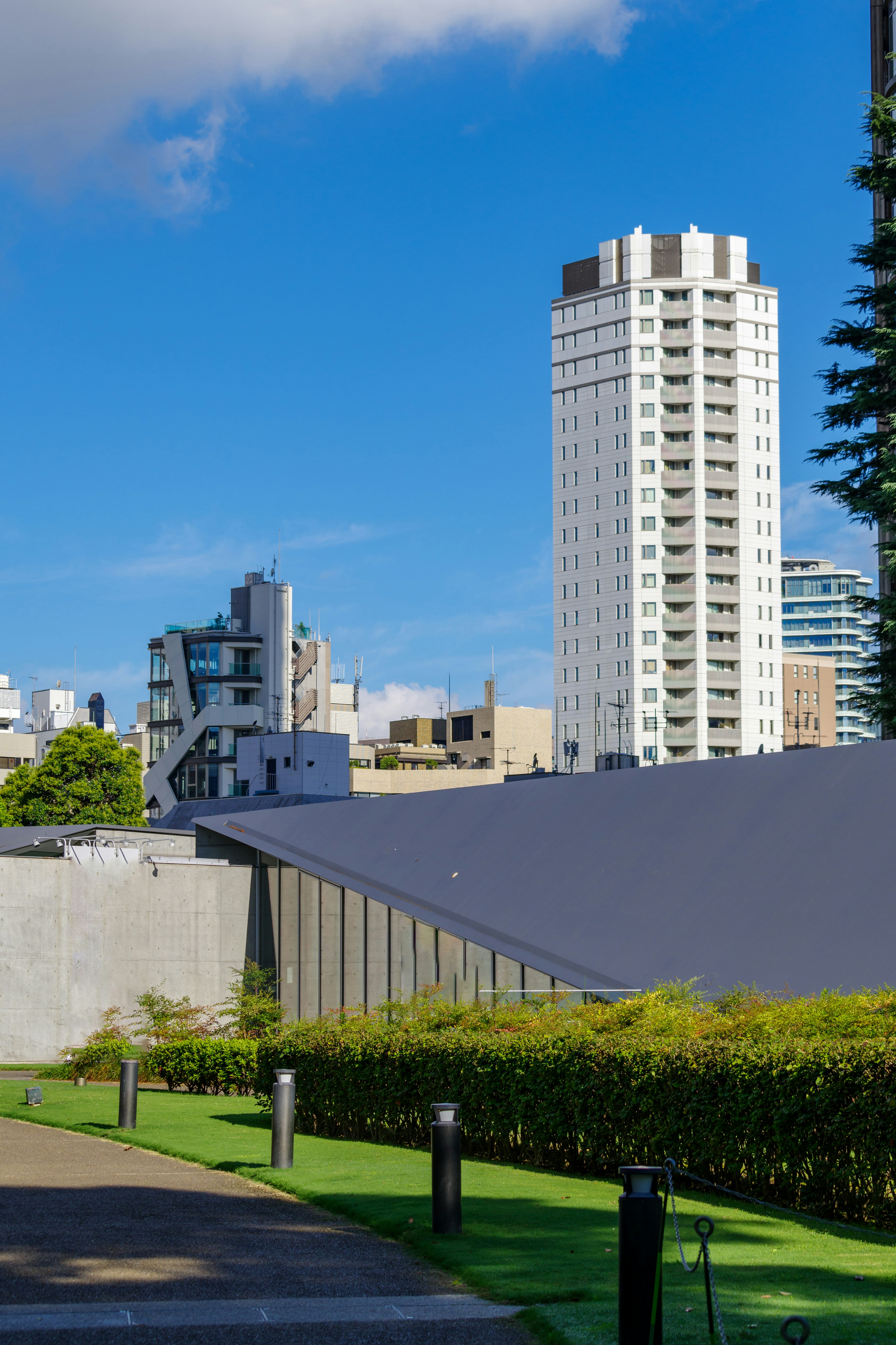 Urban landscape featuring tall buildings and greenery under a blue sky