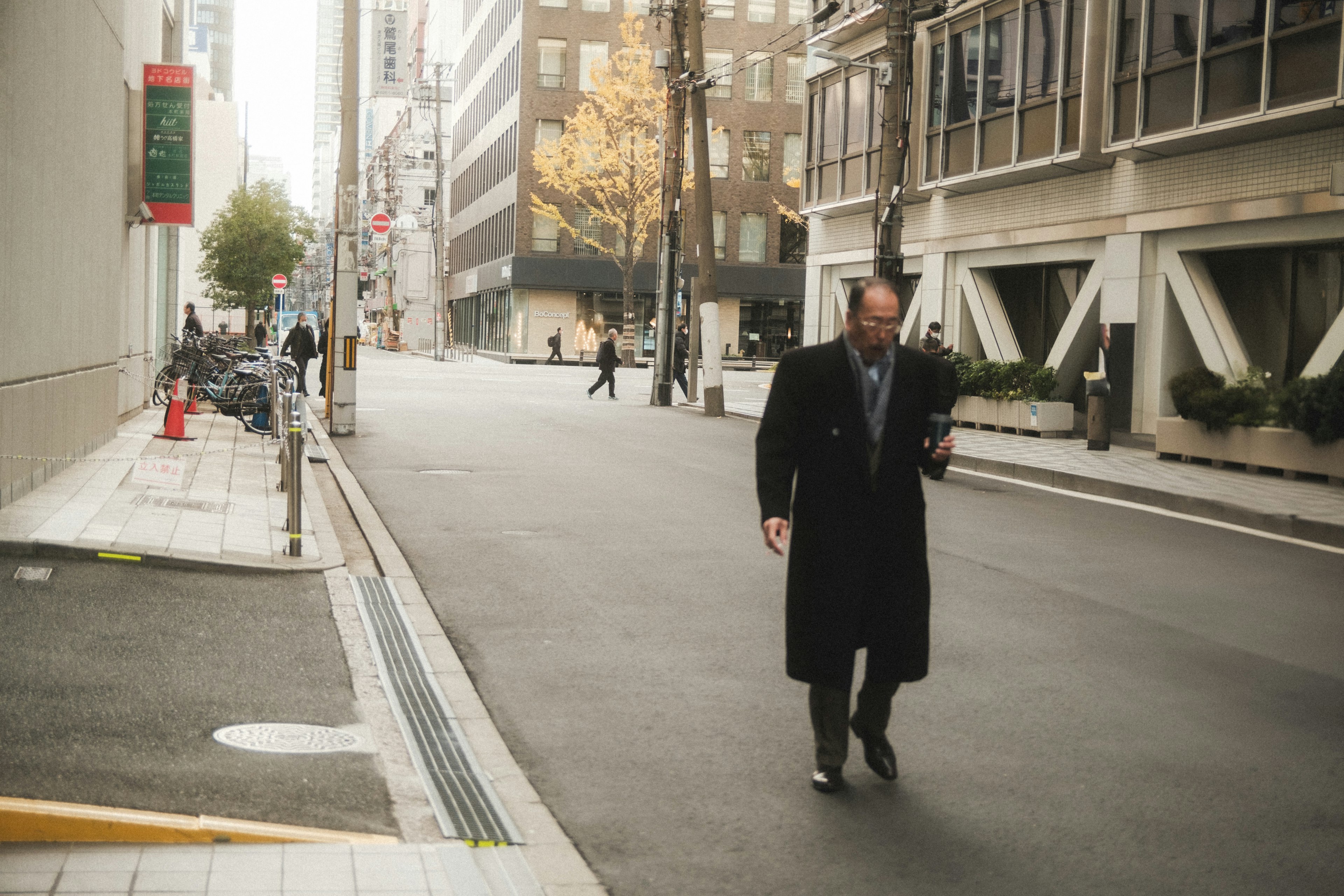 Businessman walking on a city street wearing a coat